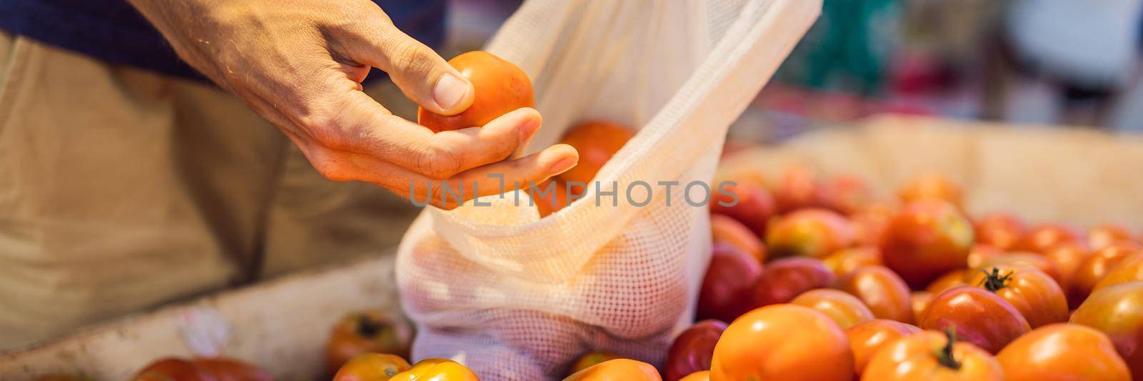 Man chooses tomatoes in a supermarket without using a plastic bag. Reusable bag for buying vegetables. Zero waste concept BANNER, LONG FORMAT by galitskaya