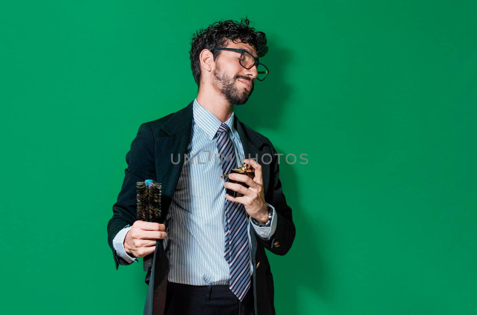 elegant businessman perfuming himself and combing his hair, Businessman painting and perfuming himself isolated
