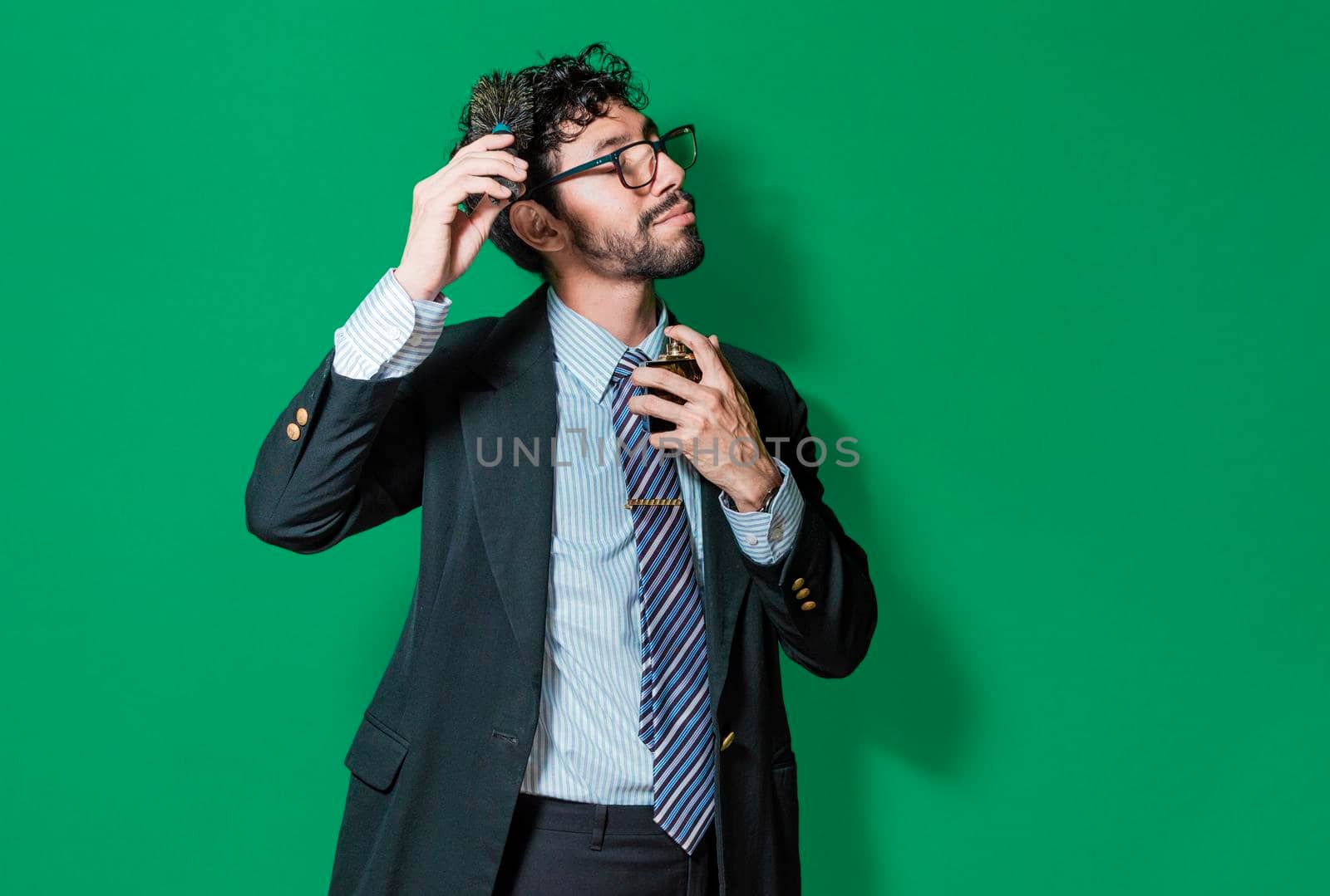 elegant businessman perfuming himself and combing his hair, Businessman painting and perfuming himself isolated