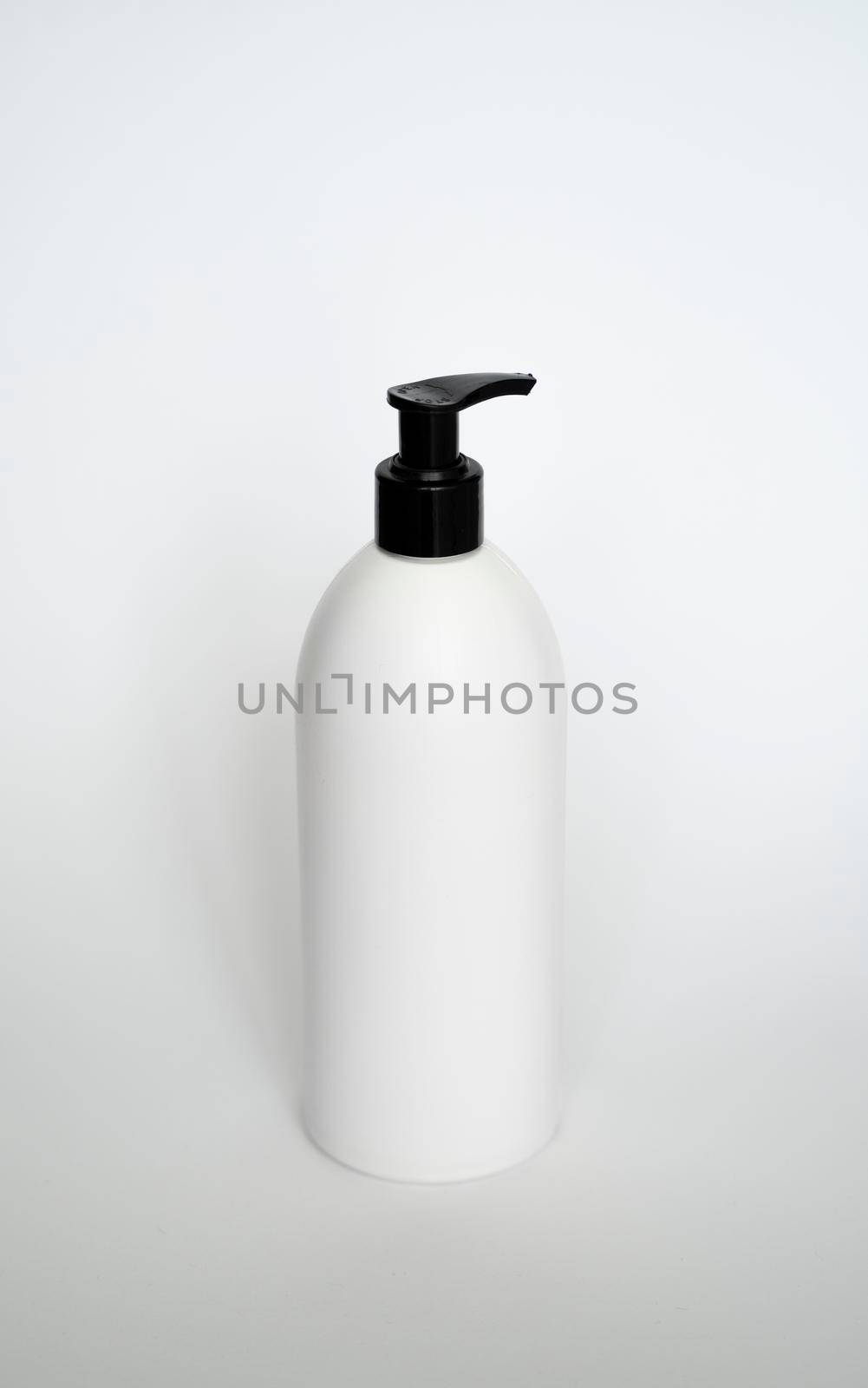Large white plastic bottle with pump dispenser on white background. Mock up template for design