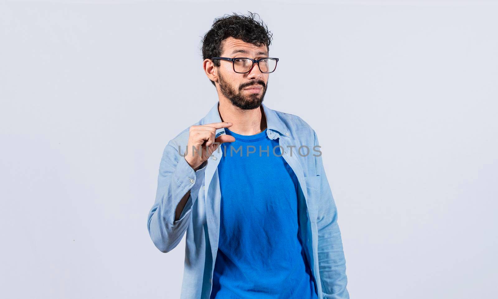 Man showing a small amount with his fingers, young man gesturing with his hand showing something small size with his fingers. Person measuring something with fingers