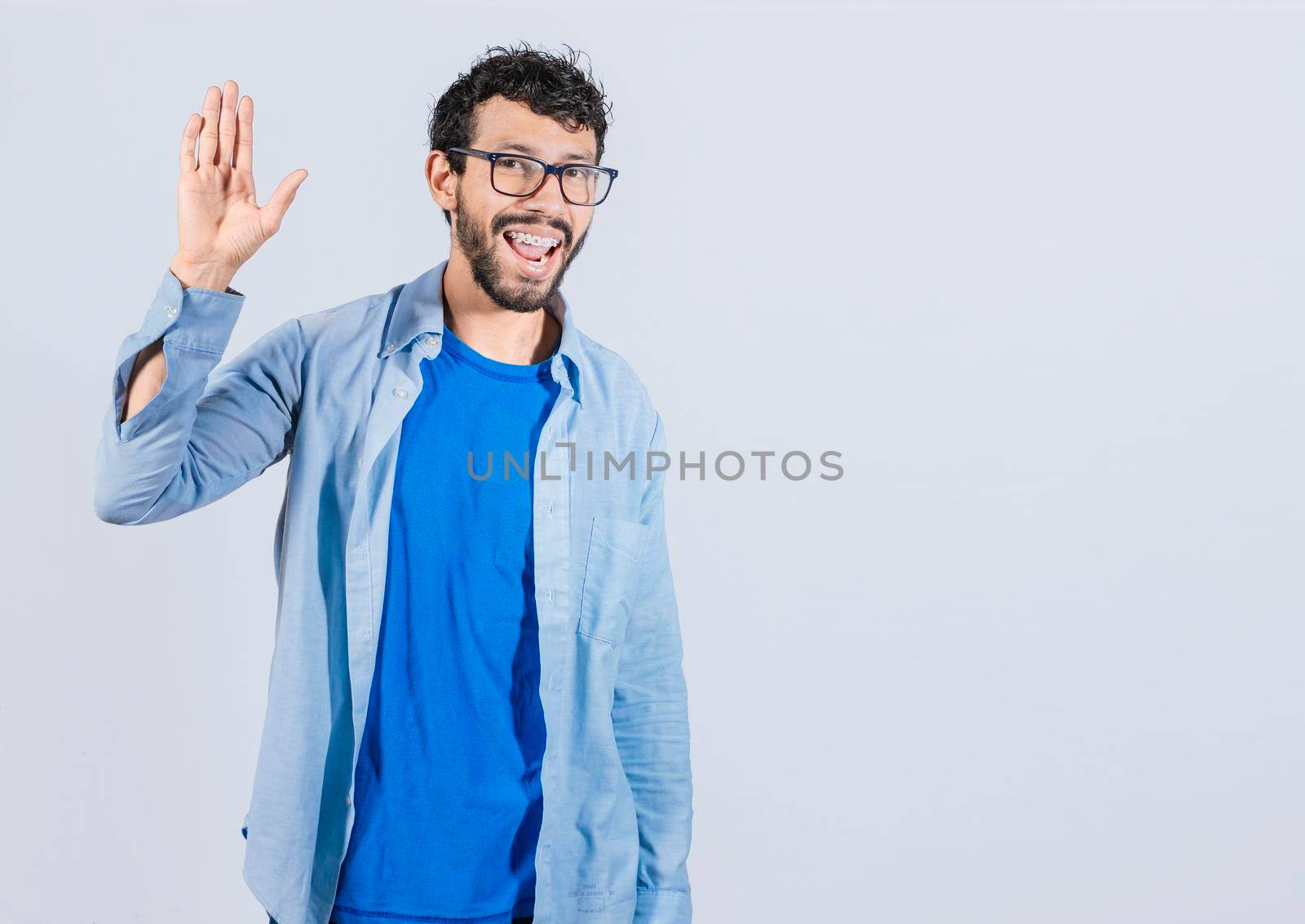 Man raising arm and waving friendly, isolated handsome man saying hi, friendly face man saying goodbye, concept of man saying hi on isolated background