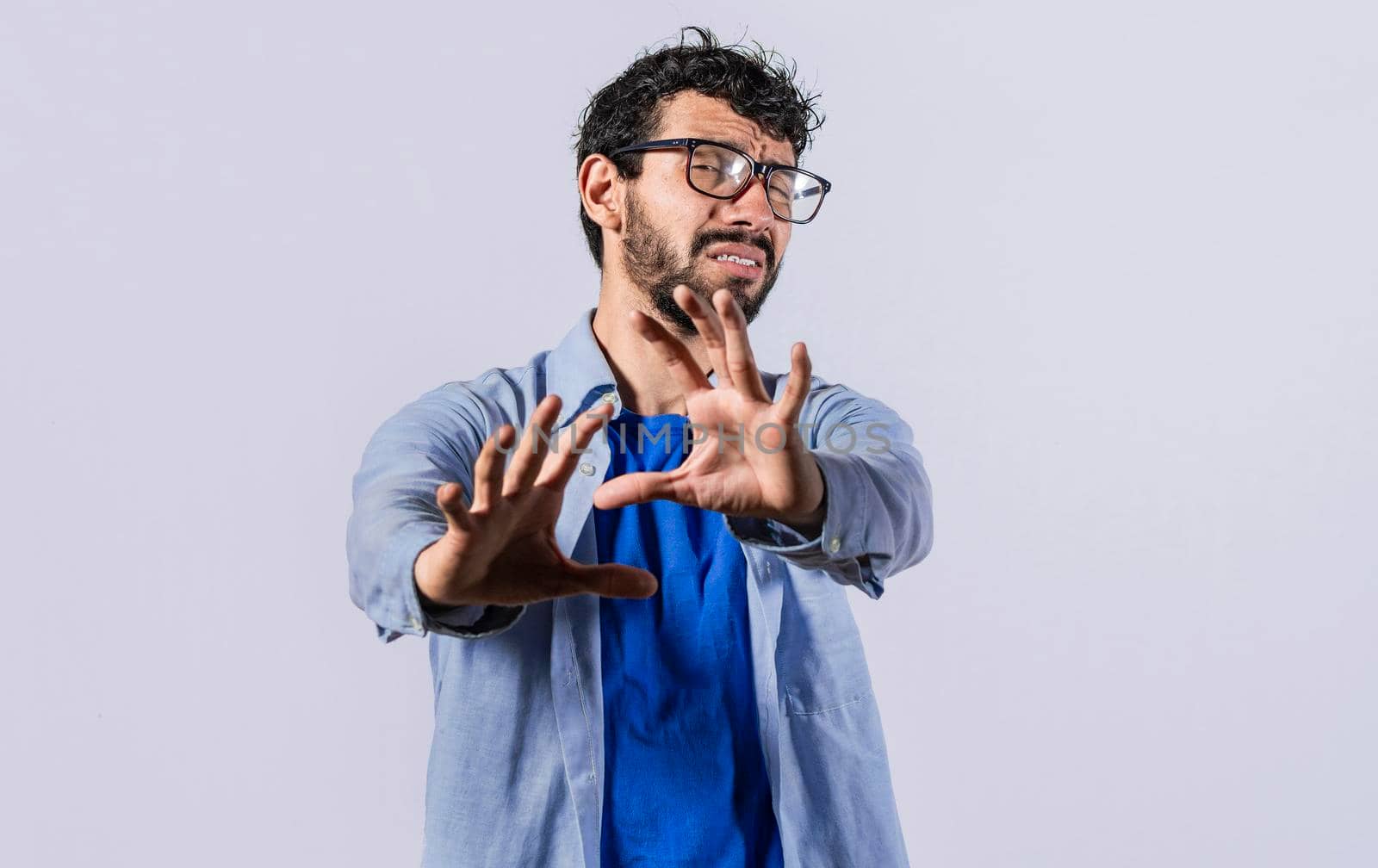 a man with rejection expression, man with scared expression on his face making frightened gesture with his palms, scared man asking you to stop