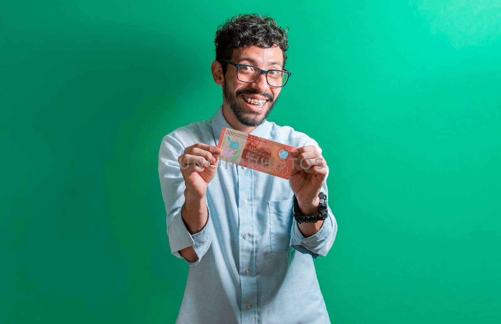 Latin man isolated a money bill, happy guy with a 500 cordobas bill, a 500 cordobas bill.