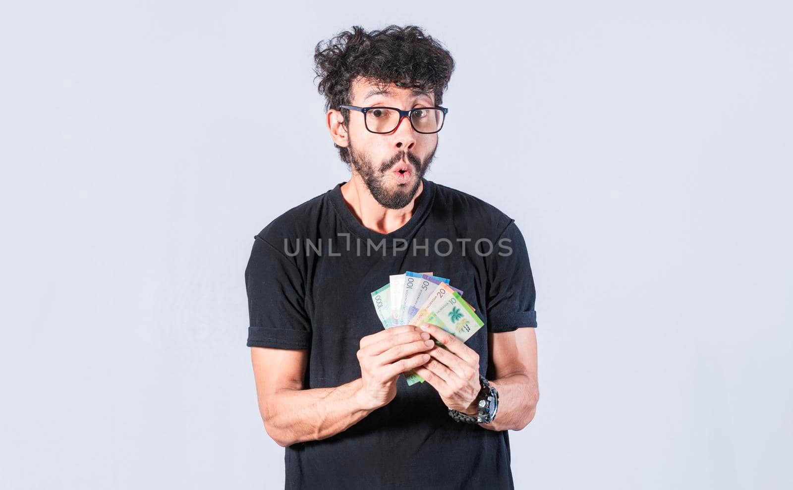 Amazed man with money in hand, man in glasses amazed with banknotes in hand, concept of man earning money