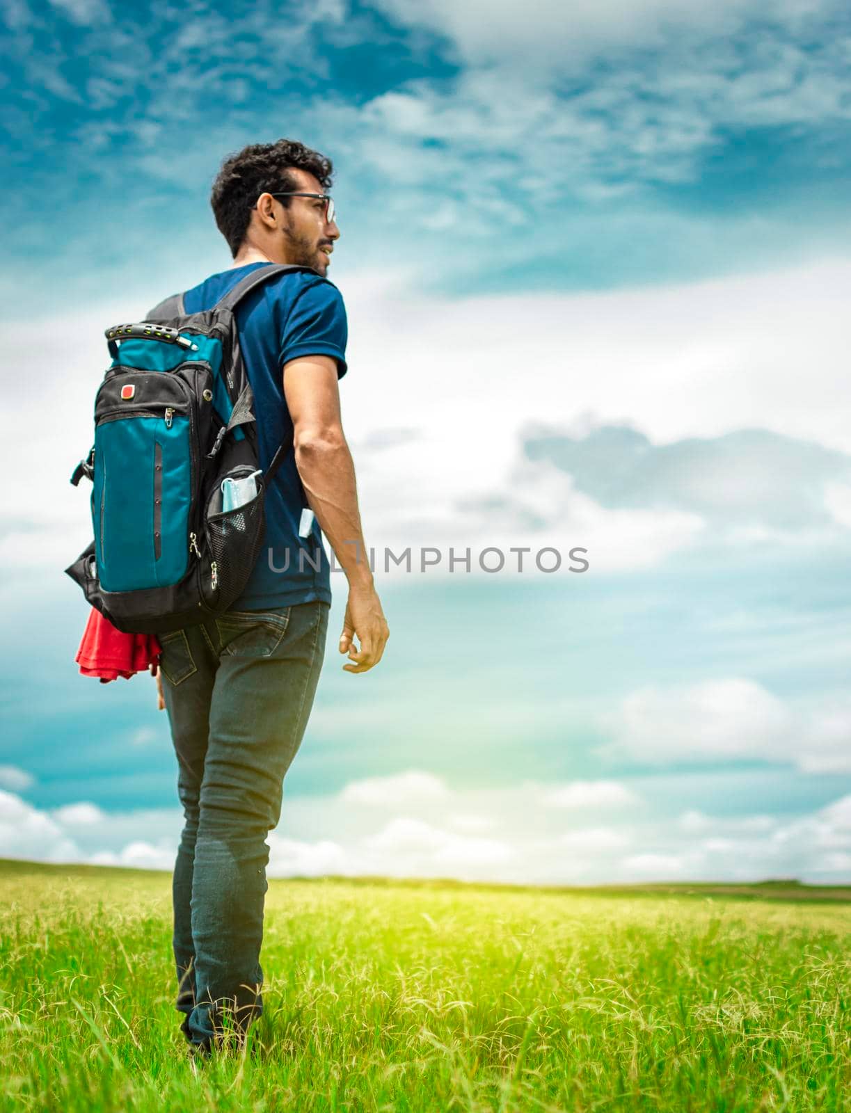 Adventurous man in the field, man with backpack in the field by isaiphoto