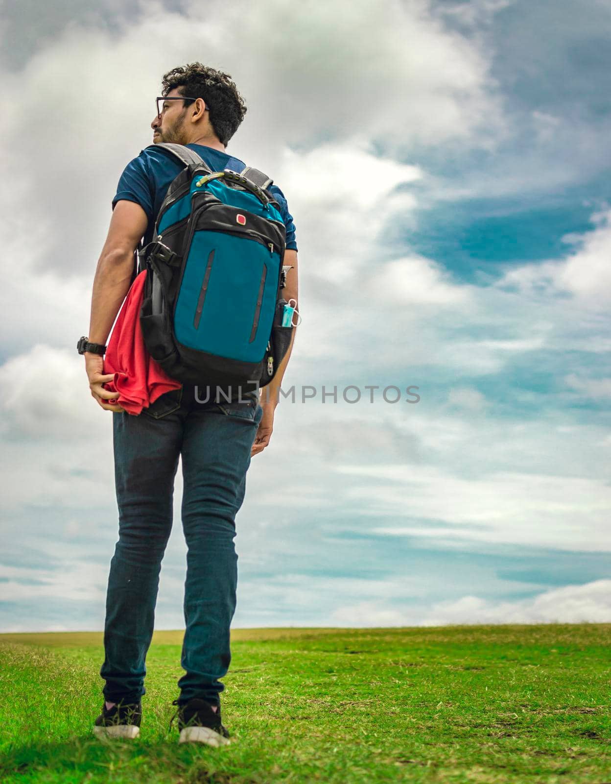 Adventurous man in the field, man with backpack in the field looking by isaiphoto