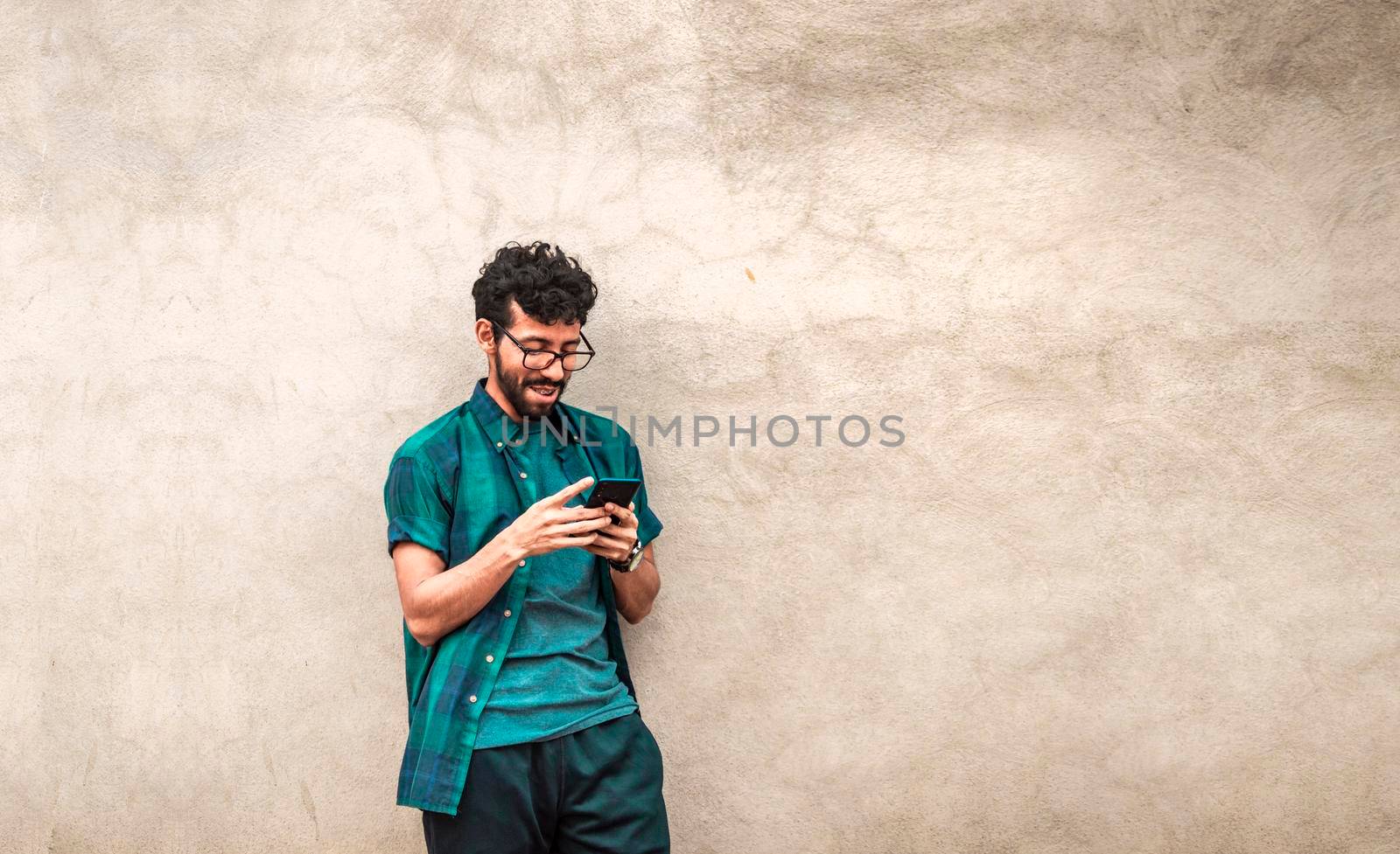 Handsome guy happy with his cell phone, young latin man happy with his cell phone