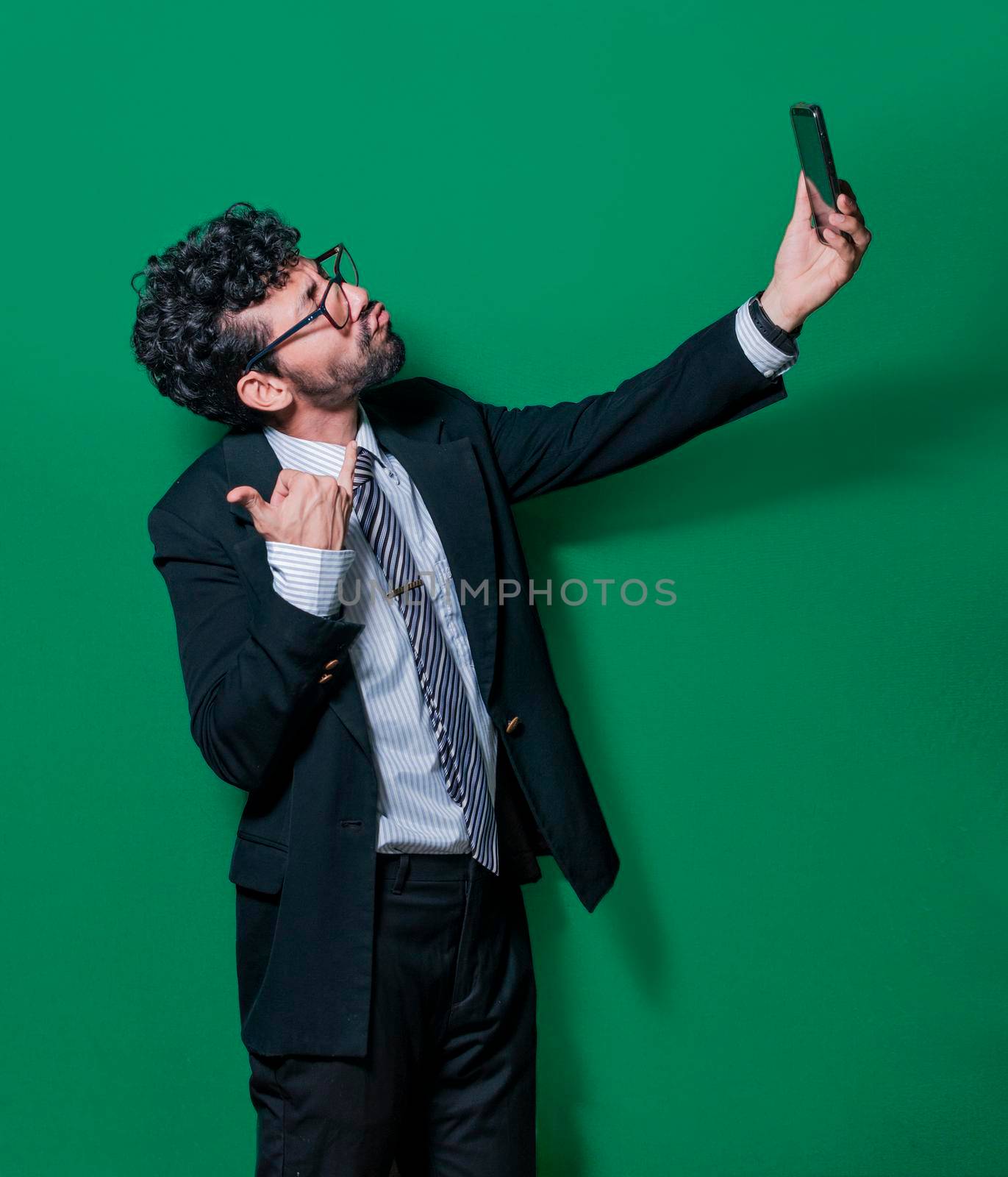 Businessman taking a selfie isolated, young businessman taking a funny selfie