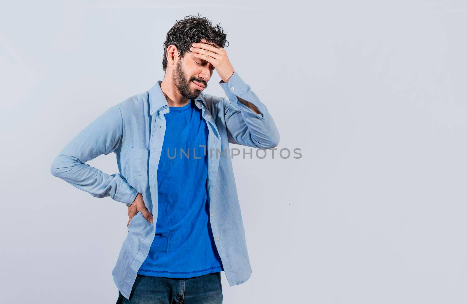 Worried young man holding his forehead, Worried man isolated, tired man holding his head, man with headache