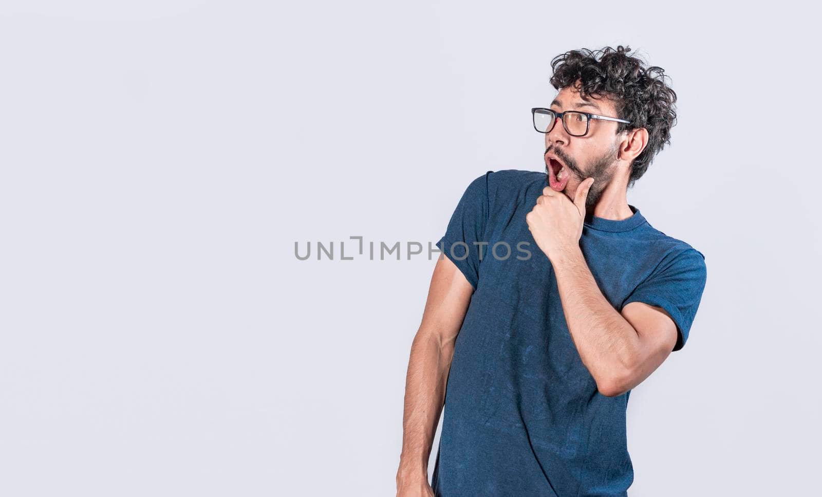 Amazed young man with hand near open mouth, man looking aside with face scared expression, surprised guy on isolated background by isaiphoto