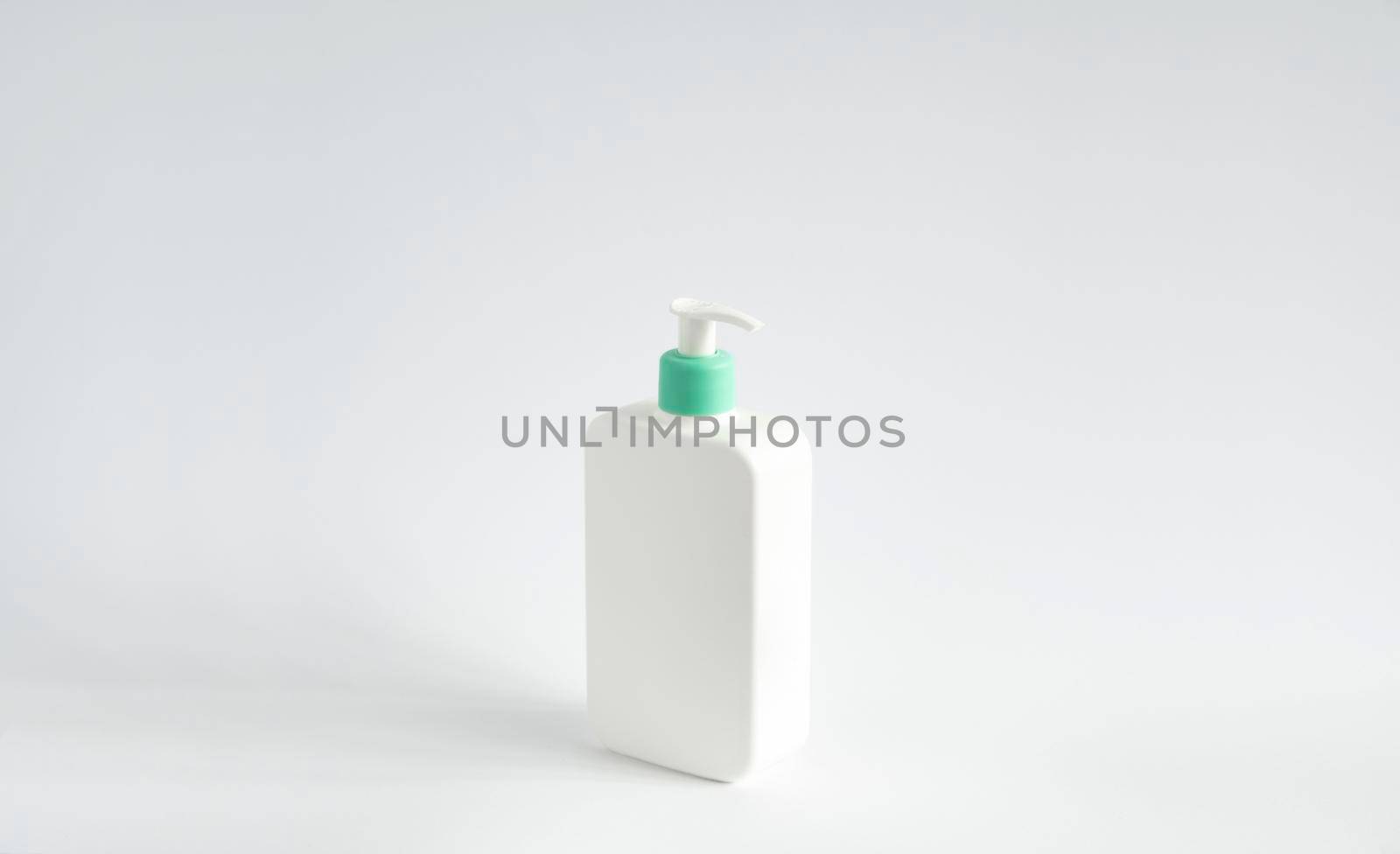 Liquid container for gel, lotion, cream, shampoo, bath foam. Cosmetic plastic bottle with green dispenser pump on white background. Cosmetic packaging mockup with copy space. by vovsht