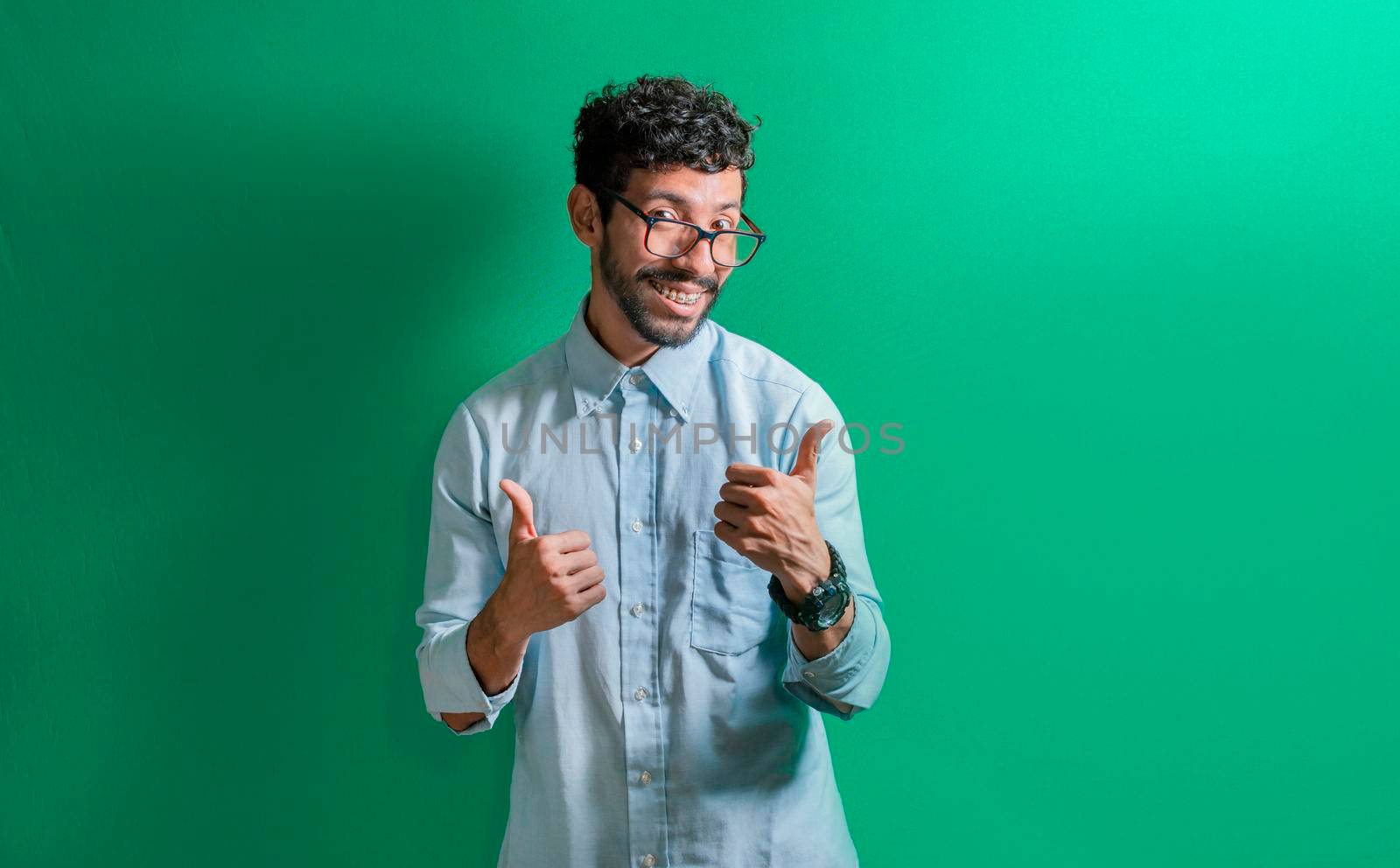 young man with thumbs up, positive guy with thumbs up isolated. by isaiphoto