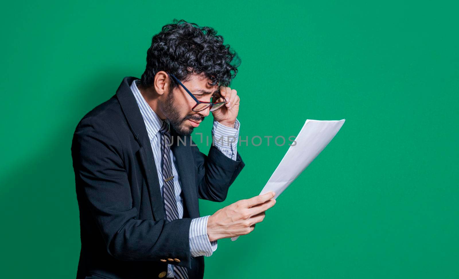 Confused businessman with documents in hand, puzzled businessman with documents in hand by isaiphoto
