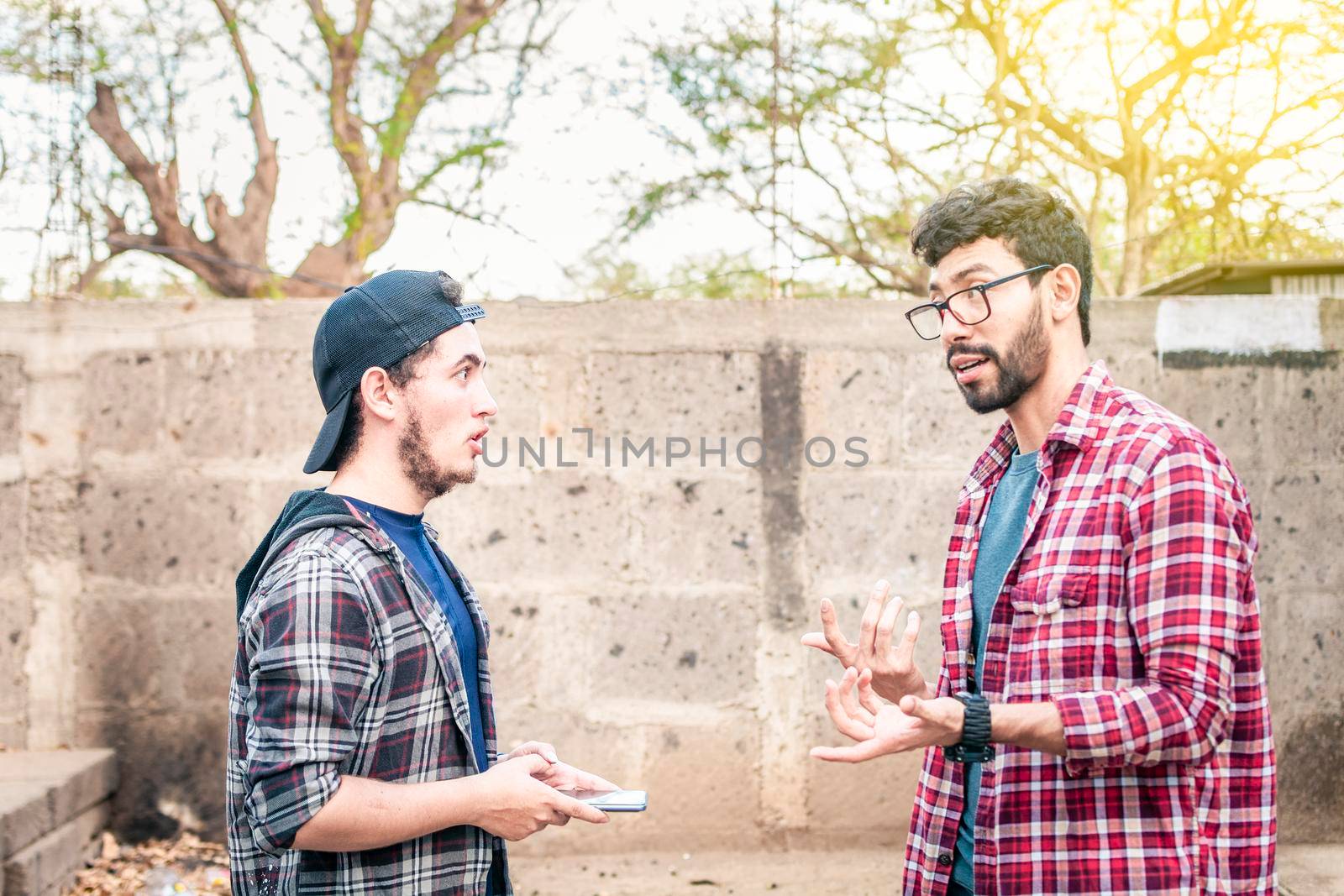 Two young people having a conversation outdoors, two friends having a conversation, concept of respect and friendly conversation by isaiphoto