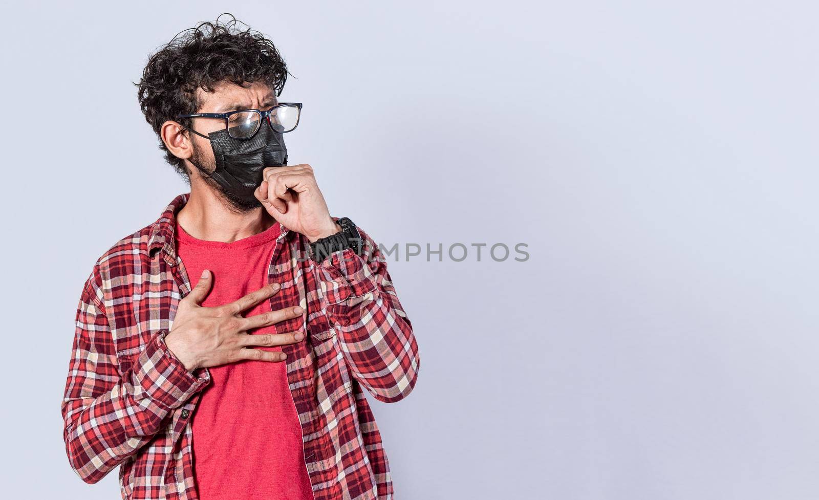 Man coughing with surgical mask, coronavirus outbreak, social distancing and respiratory problems concept by isaiphoto