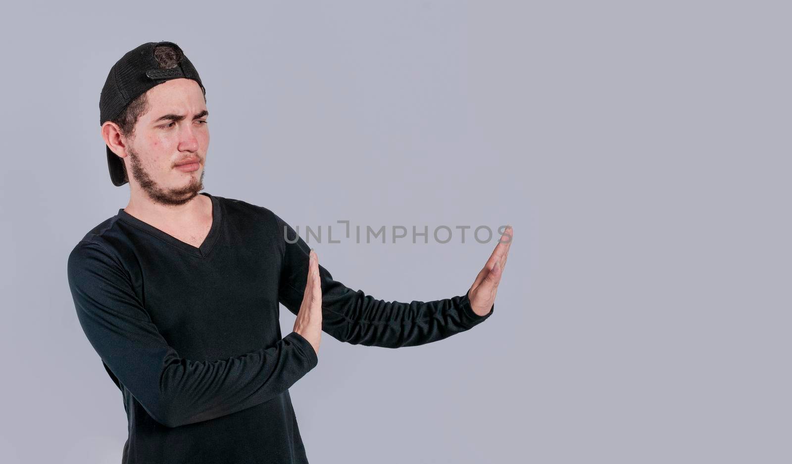 Disgusted intense man with rejection gesture, pulls palms in rejection, frowns in disgust
