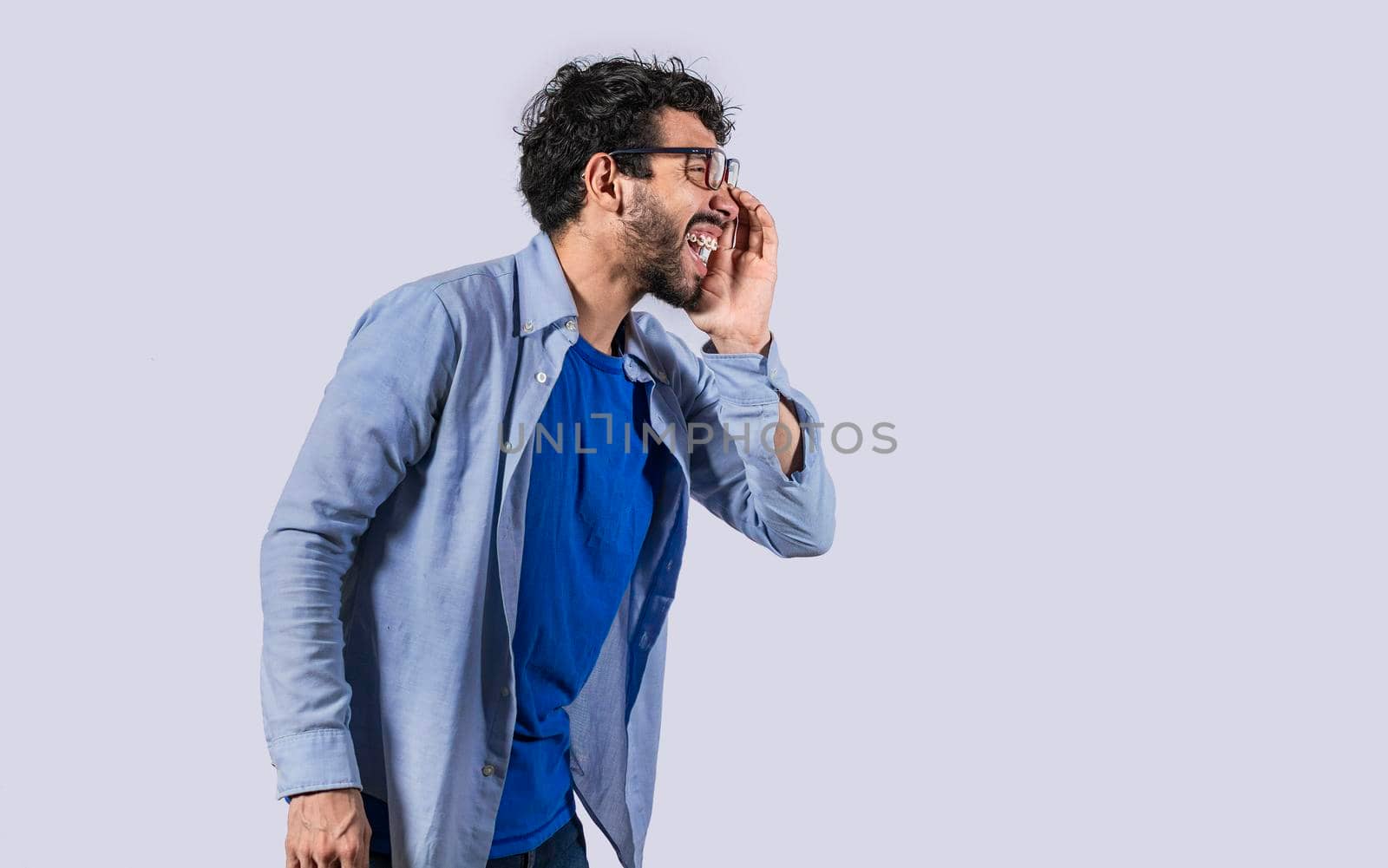 Side view of a man shouting out loud, A person announcing and yelling, side view of a man holding hand near mouth announcing news by isaiphoto
