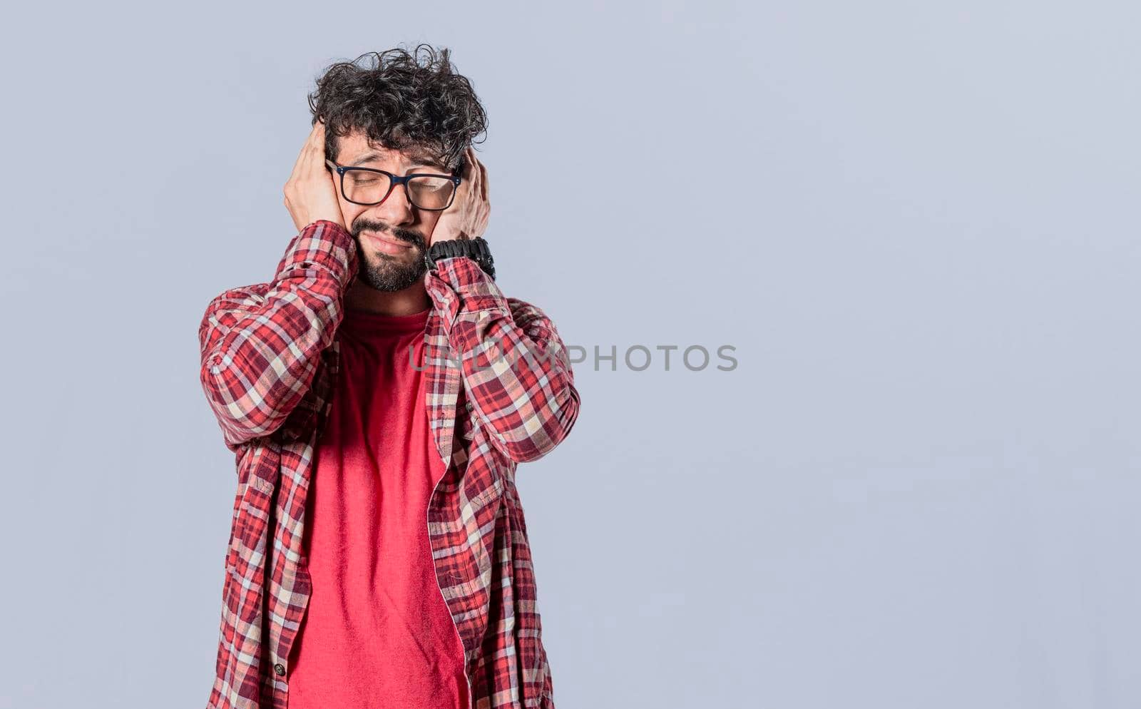 Man covering his ears on isolated background, a guy covering his ears, avoiding hearing, deaf ears concept,