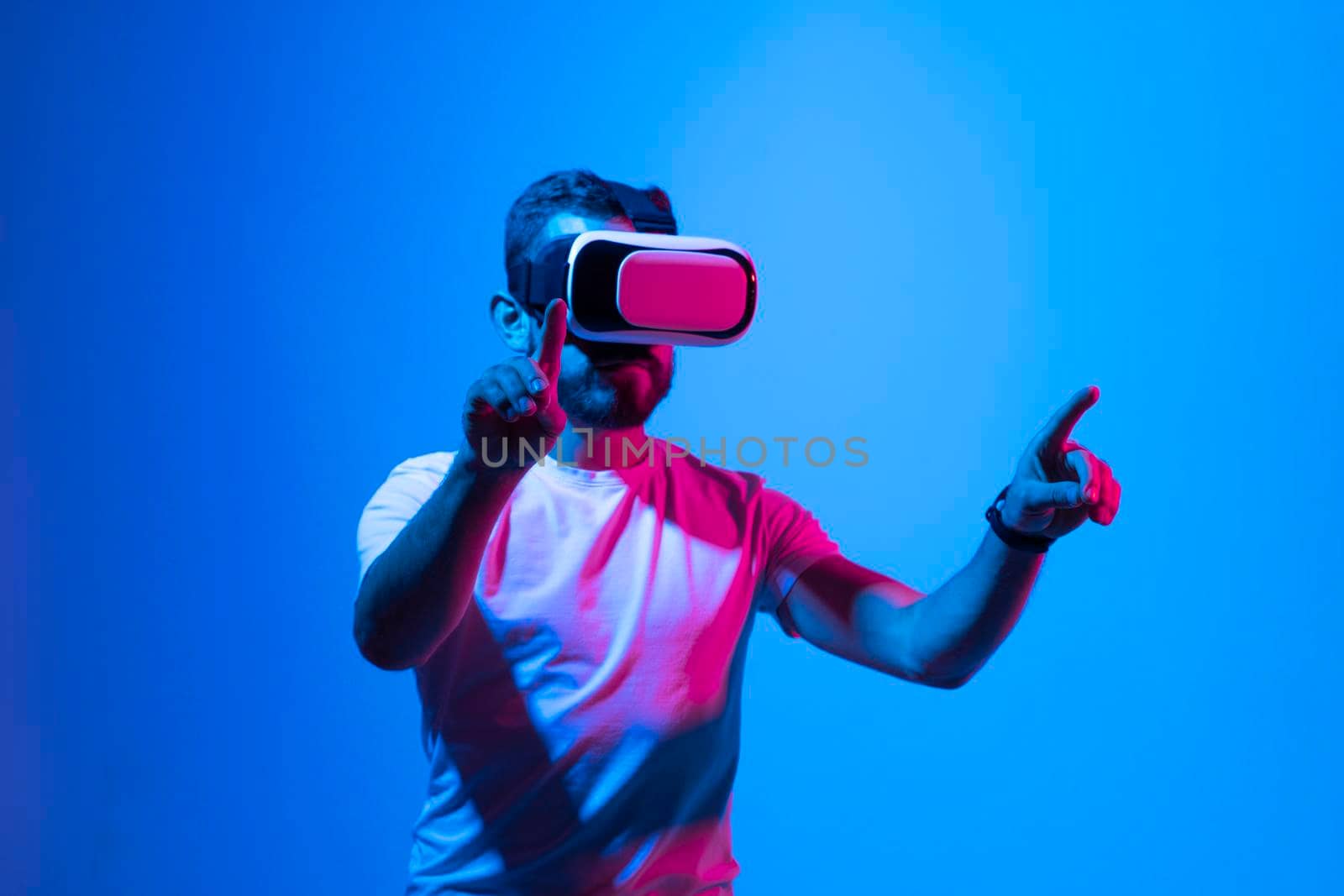 Vitrual reality concept. Man are playing a game in virtual reality. Young man in VR glasses are gaming with realistic holograms in simulator. Entertainment and leisure concept. Modern technologies