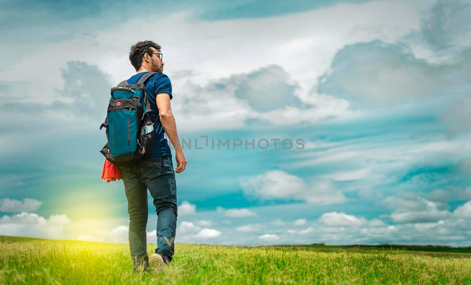 Adventurous man in the field, man with backpack in the field looking