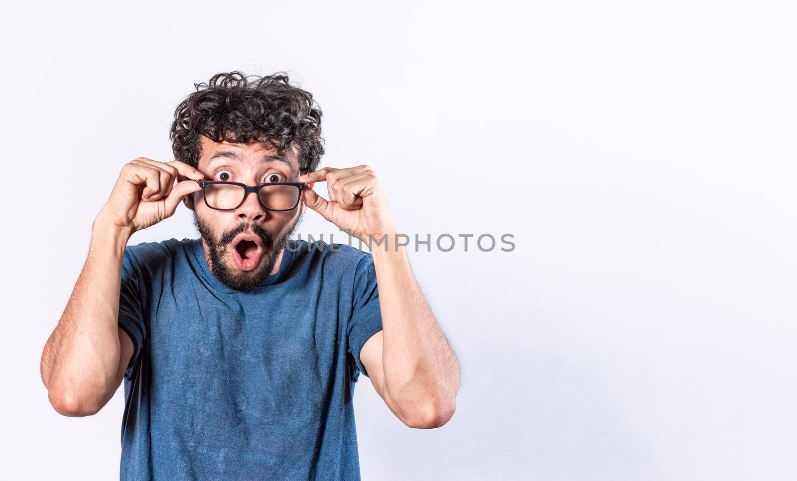 Surprised glasses man holding his glasses, Emotive young caucasian man staring through big glasses,