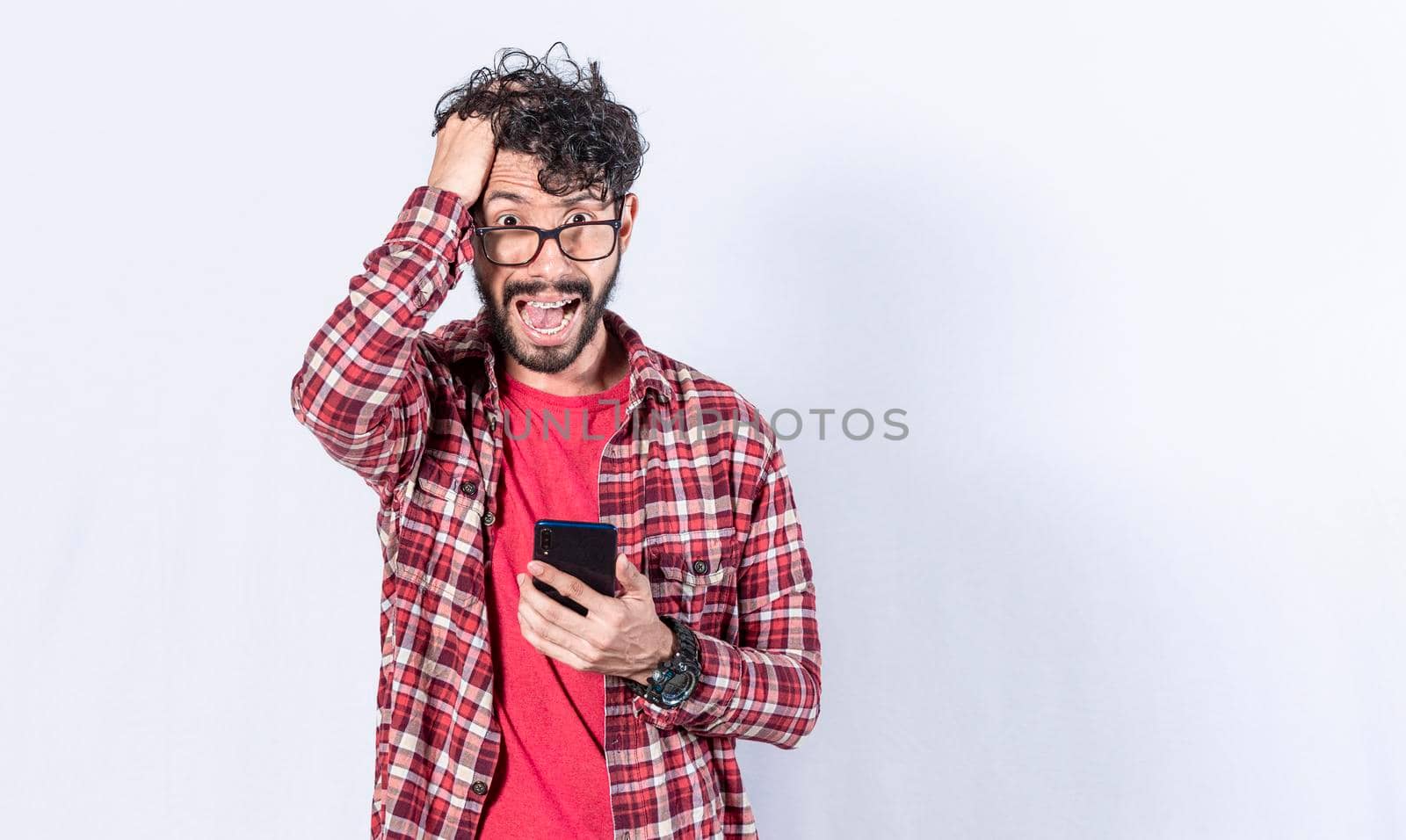 Worried young man with his phone in his hand, concept of a man stunned with his cell phone by isaiphoto