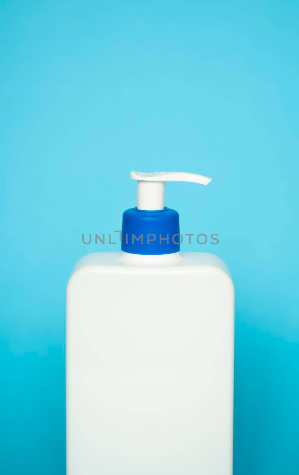 Liquid container for gel, lotion, cream, shampoo, bath foam. Cosmetic plastic bottle with blue dispenser pump on blue background. Cosmetic packaging mockup with copy space. by vovsht