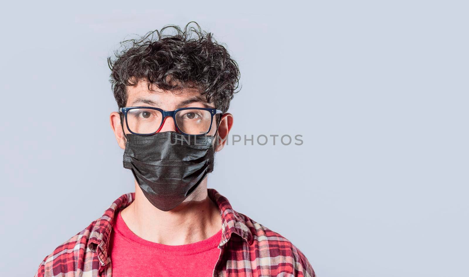 Close up of guy wearing surgical mask on isolated background, close up of handsome guy wearing protective mask