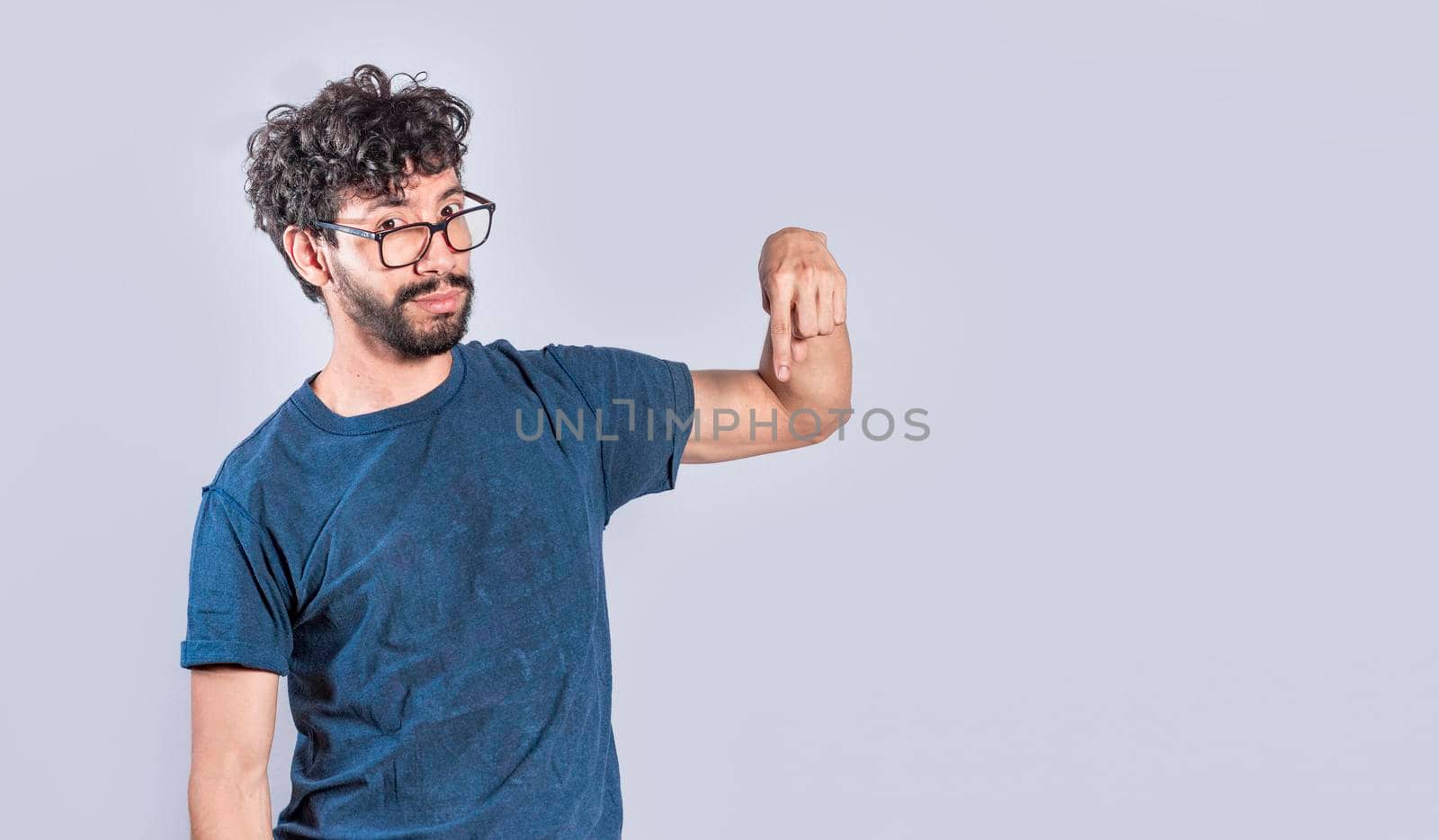 Friendly bearded man pointing down on isolated background, friendly guy pointing down and recommending