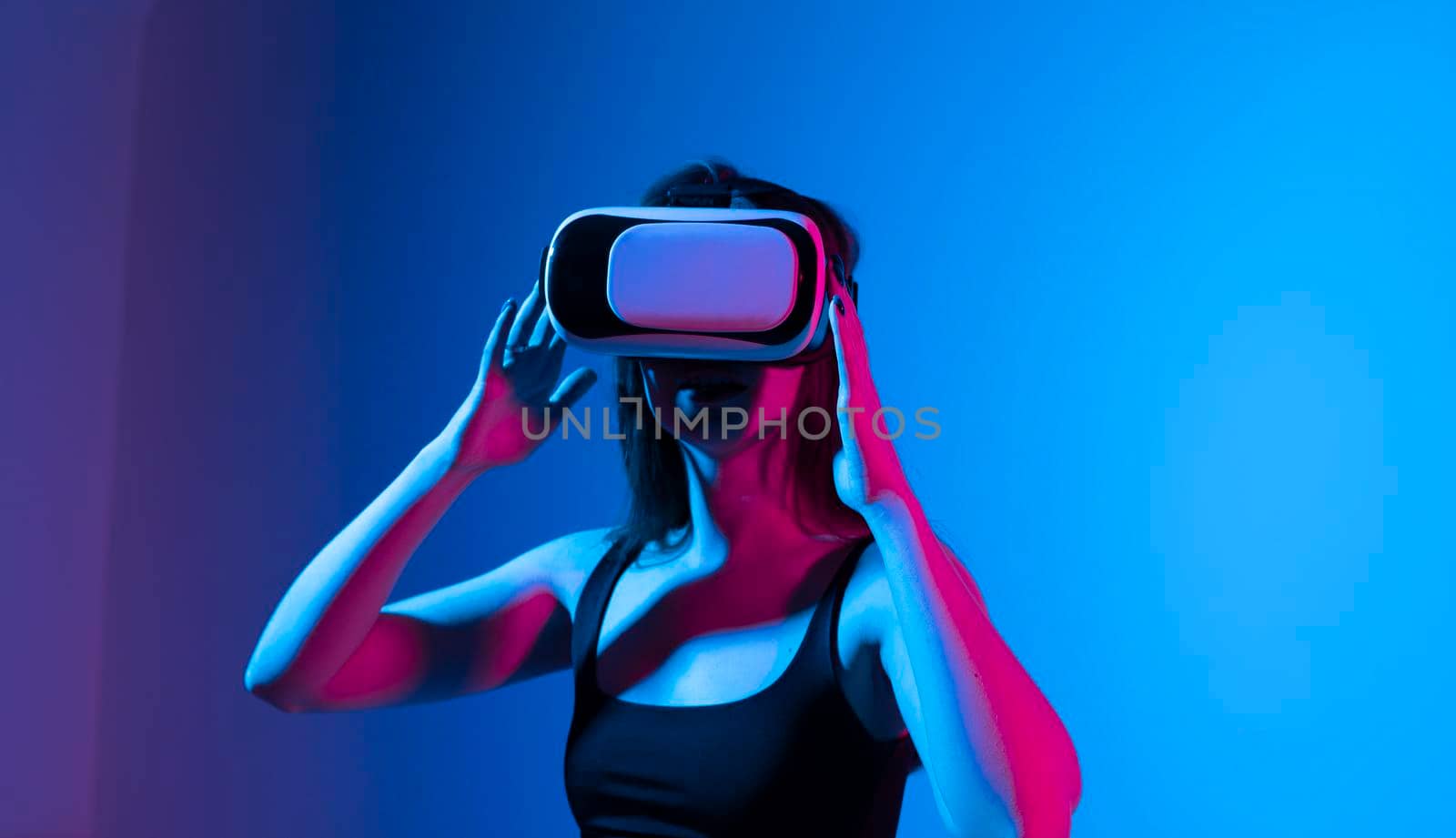 Happy brunette girl getting experience using VR headset glasses of virtual reality and exploring a new virtual world without bounds. by vovsht