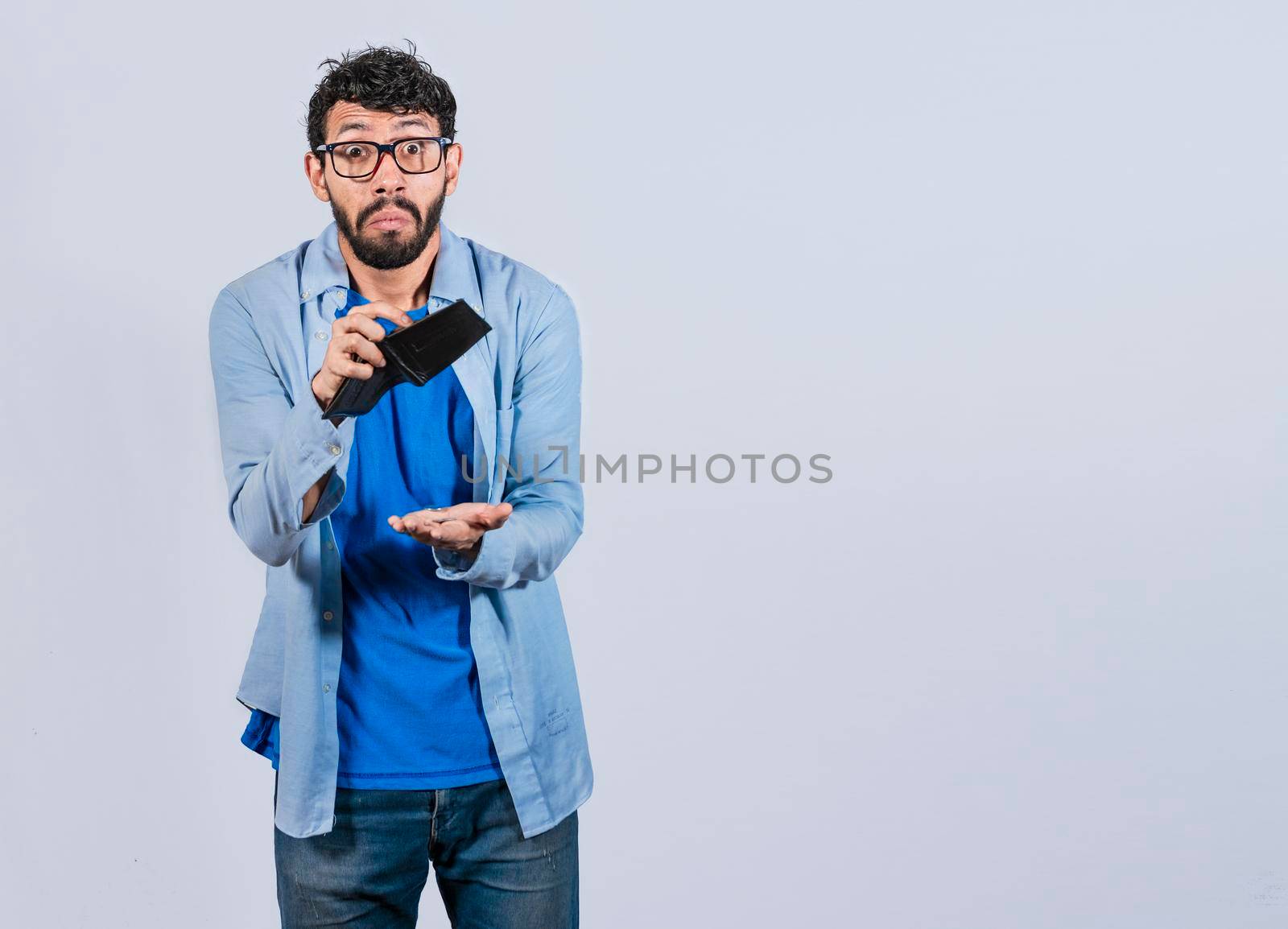 Sad man holding empty wallet and looking at the camera, Unhappy and surprised man looking into an empty wallet, Person seeing his empty wallet, Man with financial problems