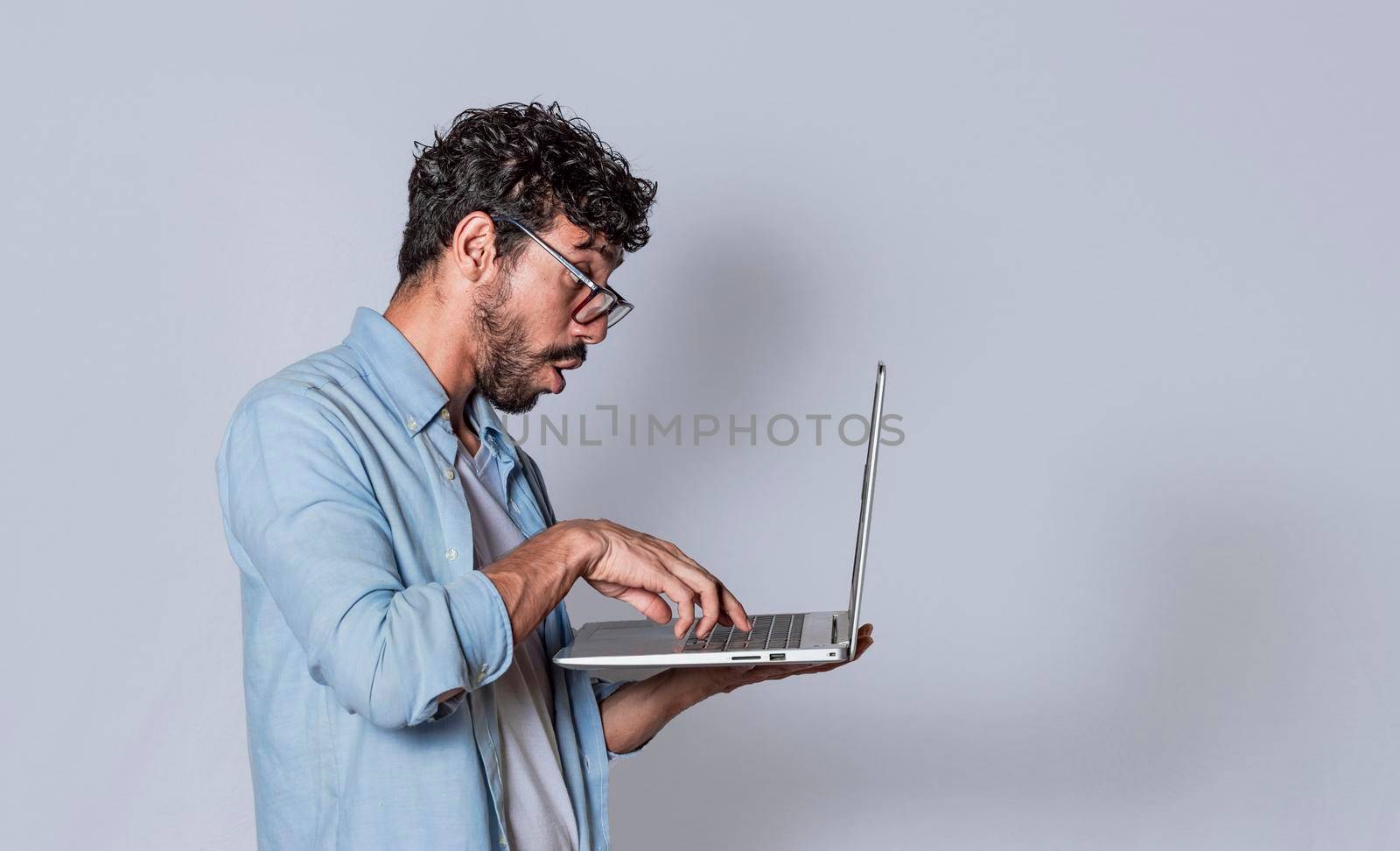 Handsome guy checking his laptop isolated, surprised man checking his laptop, guy with laptop.