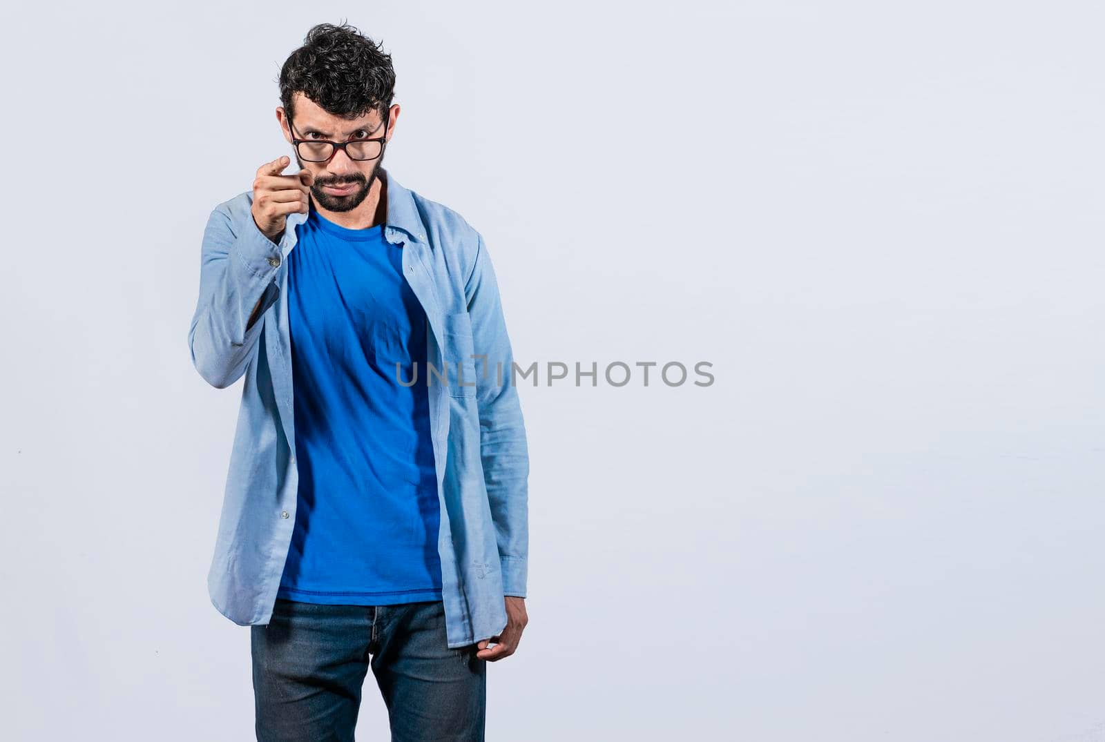 Hey you, be careful. bearded guy looking angry and warning, angry man threatening finger at camera, concept of angry person threatening head on