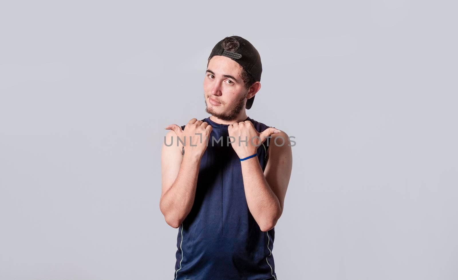 Handsome man pointing to the side, friendly guy pointing his fingers to the side, young man pointing at blank space