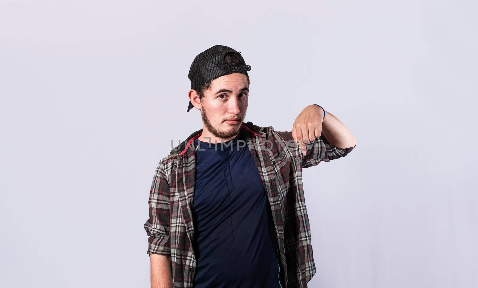 Friendly bearded man pointing down on isolated background, friendly guy pointing down and recommending