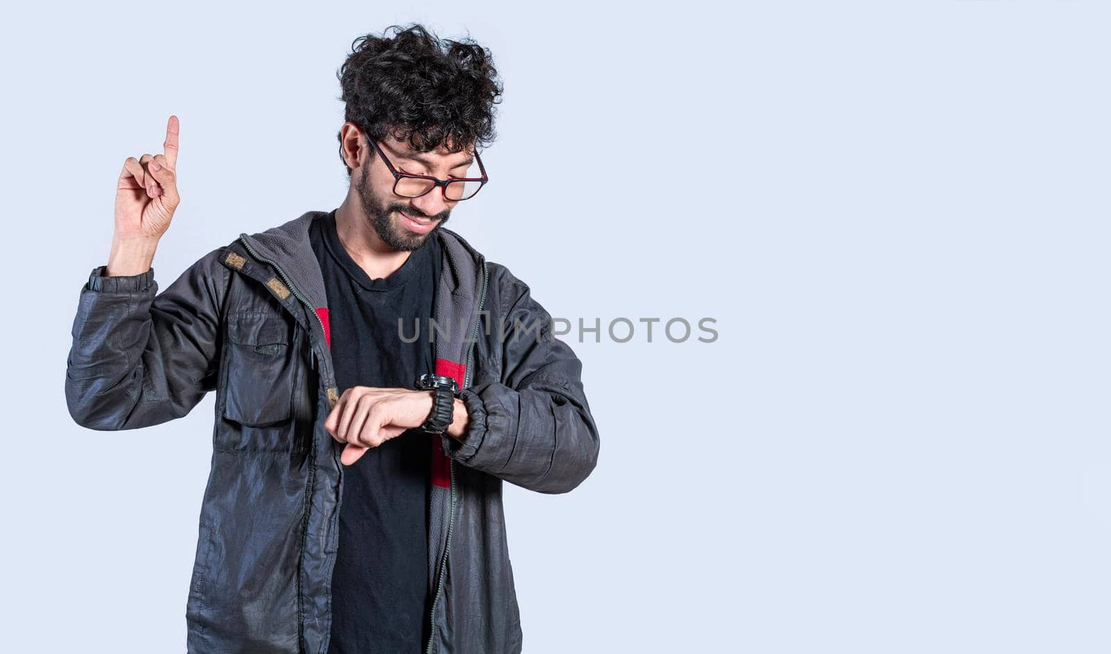 A man raising his finger with a new idea, a guy looking at his watch and raising his finger, a man measuring time with hand watch