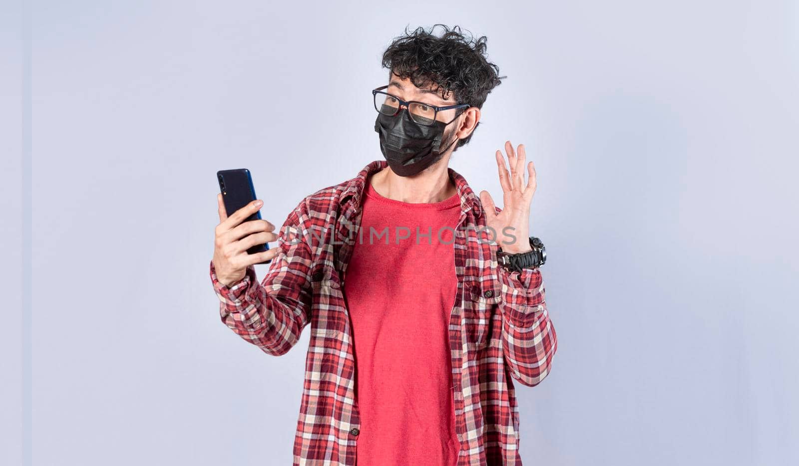 Man making video call isolated, guy making video call with face mask, face mask video call concept by isaiphoto