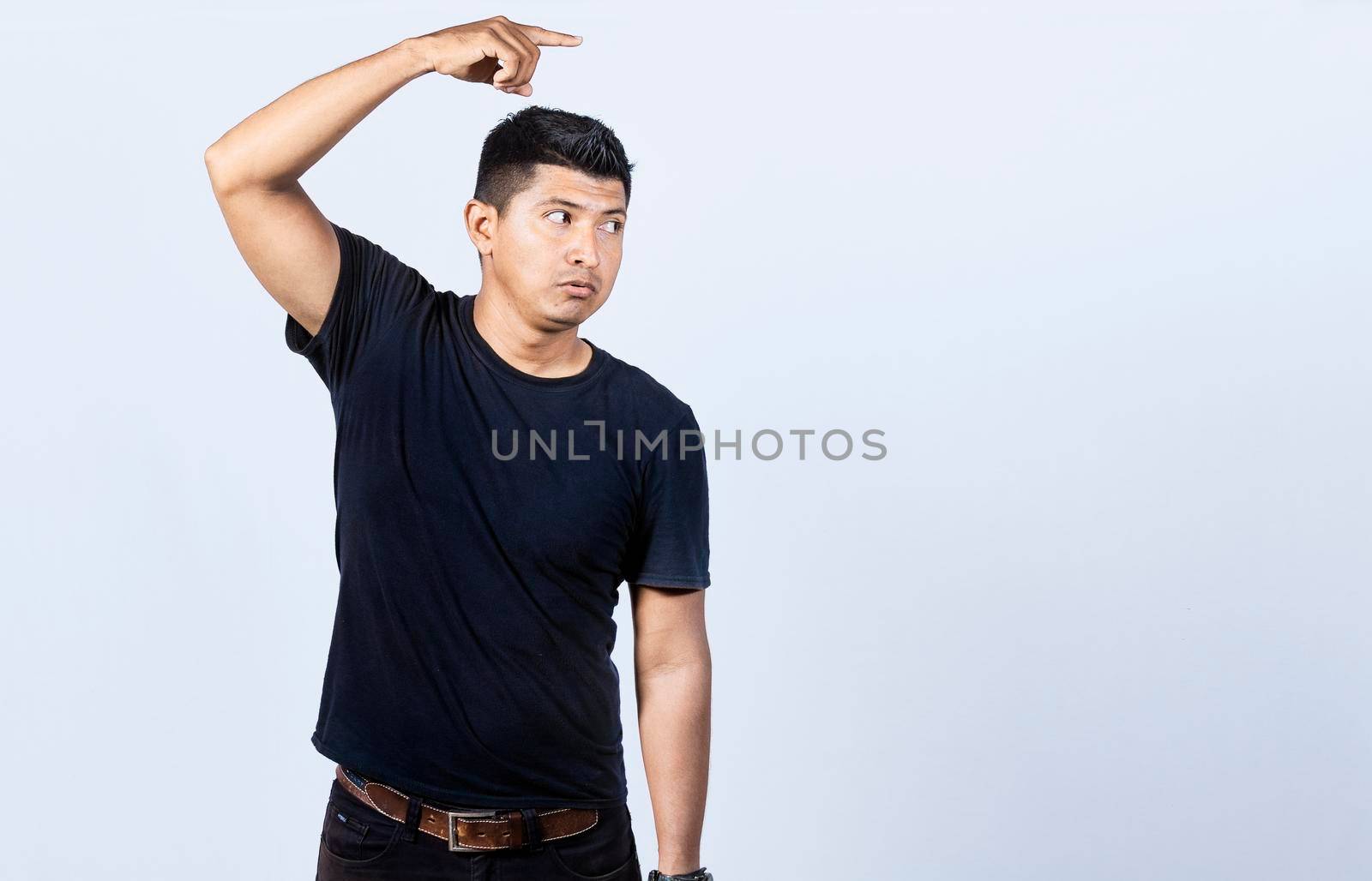 Surprised handsome man pointing to the side, Surprised guy pointing a poster, Concept of latin man pointing a banner to the side