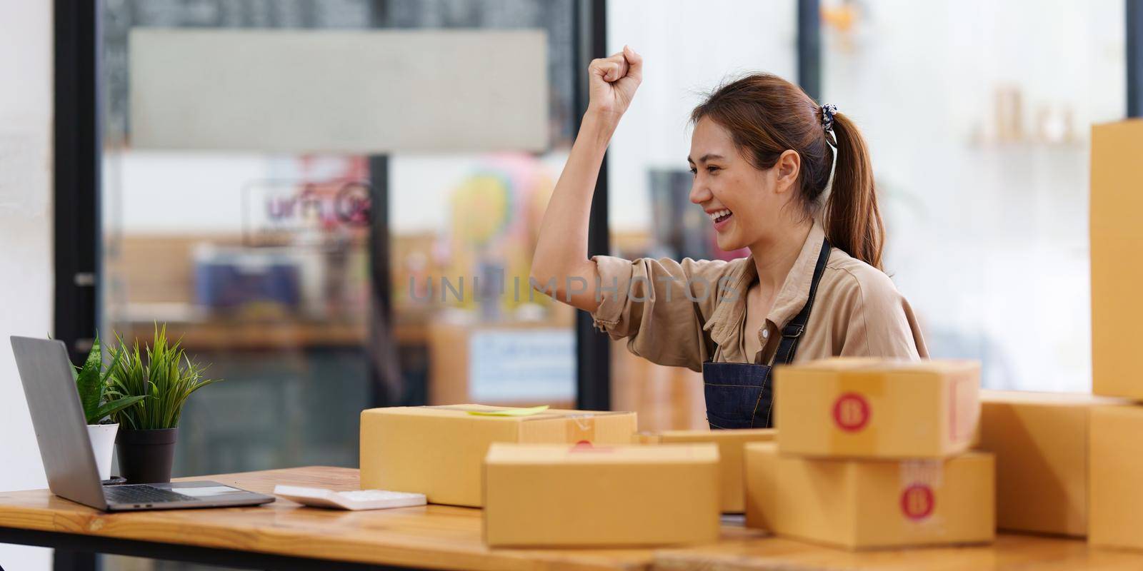 A portrait of Asian woman, e-commerce employee freelance with parcel box for deliver to customer. Online marketing packing box delivery concept