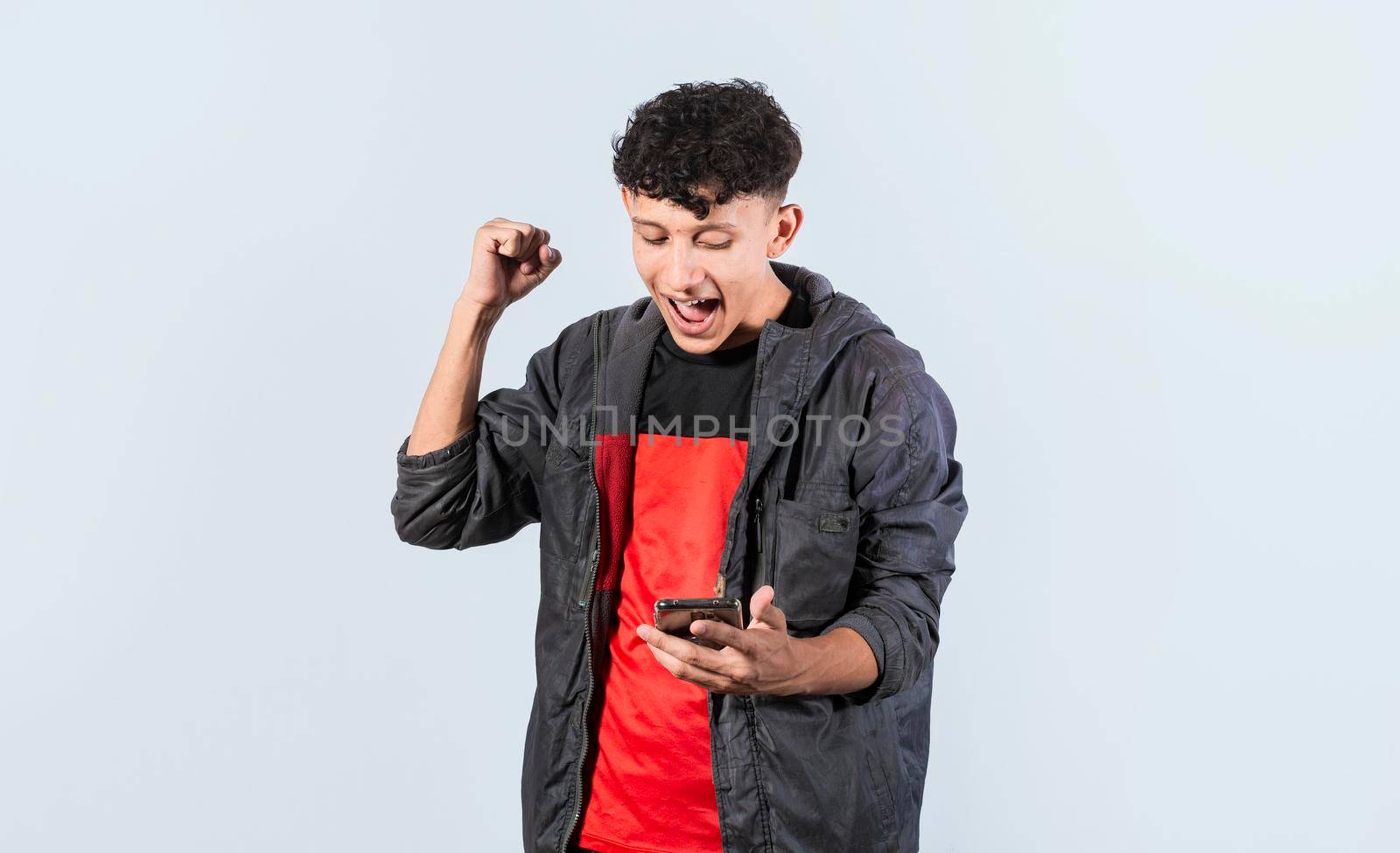 Happy man holding a smartphone and celebrating, Excited guy looking at his smartphone