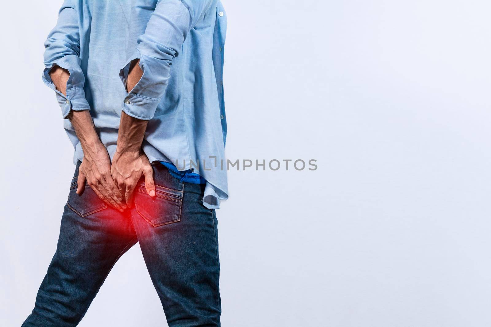 Man with digestive problem touching his buttock, man with hemorrhoid problem on isolated background, Man with diarrhea problem