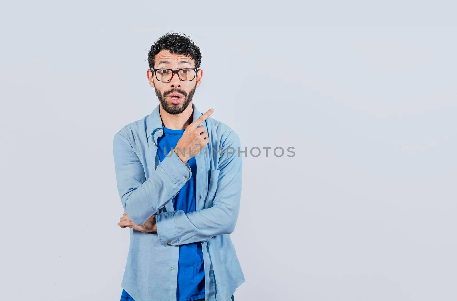 Surprised man pointing to a banner to the side, shocked guy pointing his finger to the sides, amazed man pointing to an advertisement