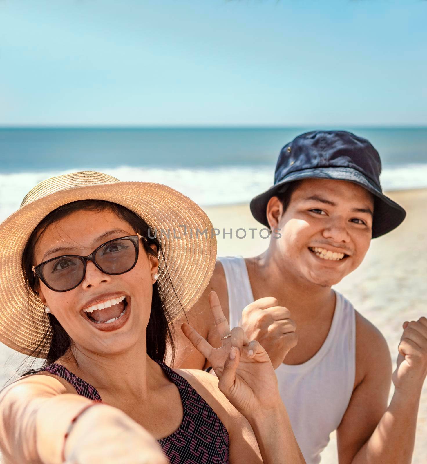 Two happy friends taking a selfie on the beach, Selfie of two happy friends on the beach by isaiphoto