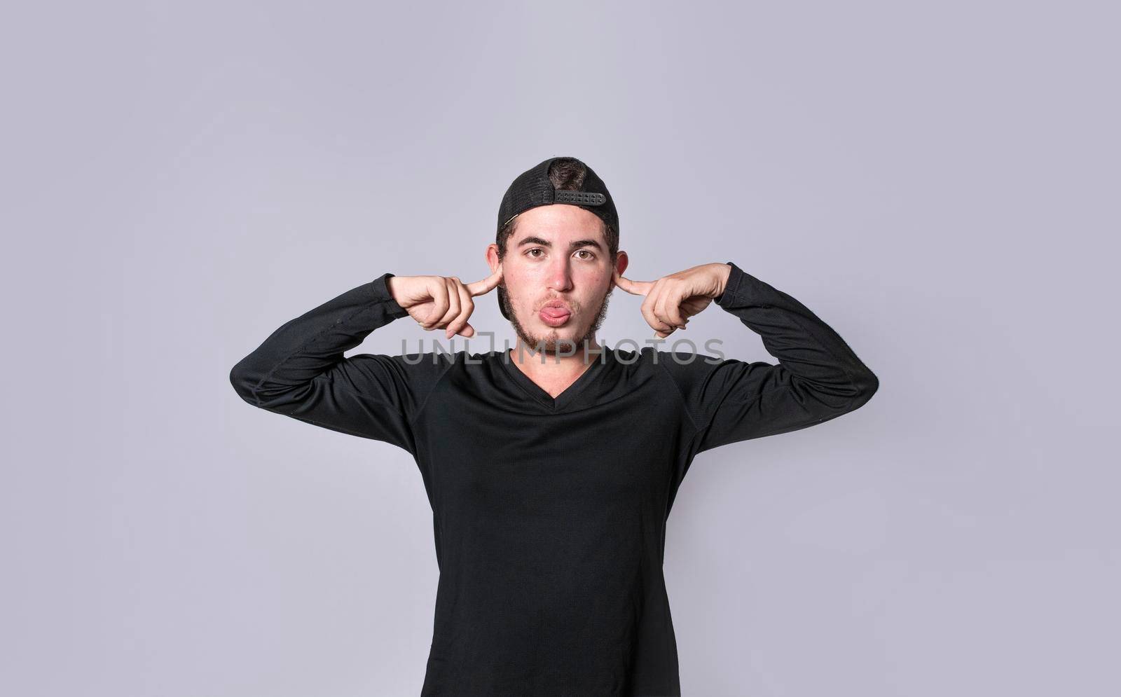 Man covering his ears isolated, guy covering his ears on isolated background, man with hands on his ears and making fun, man ignoring problems