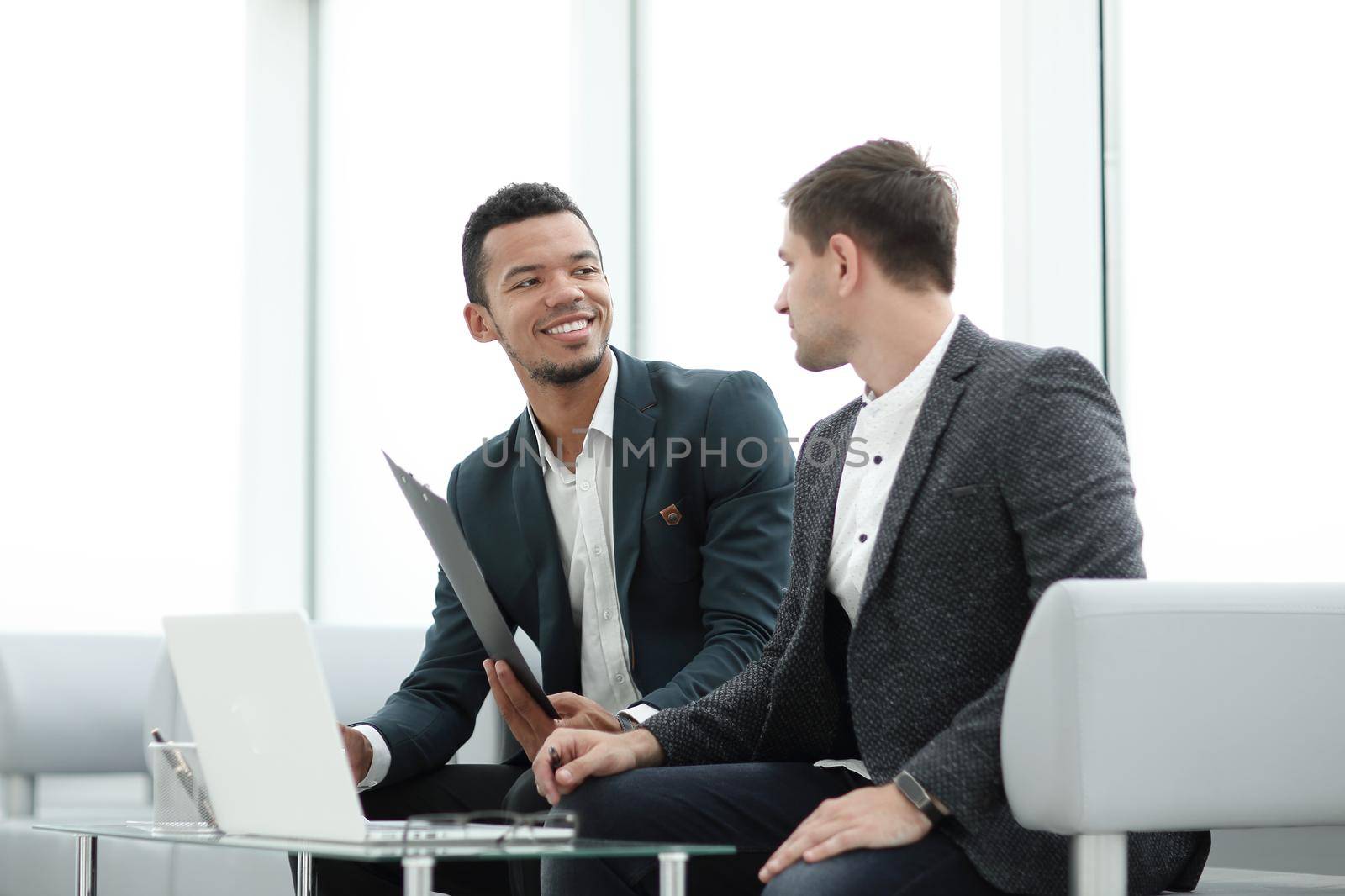two business people discuss business documents at a meeting in the office by SmartPhotoLab