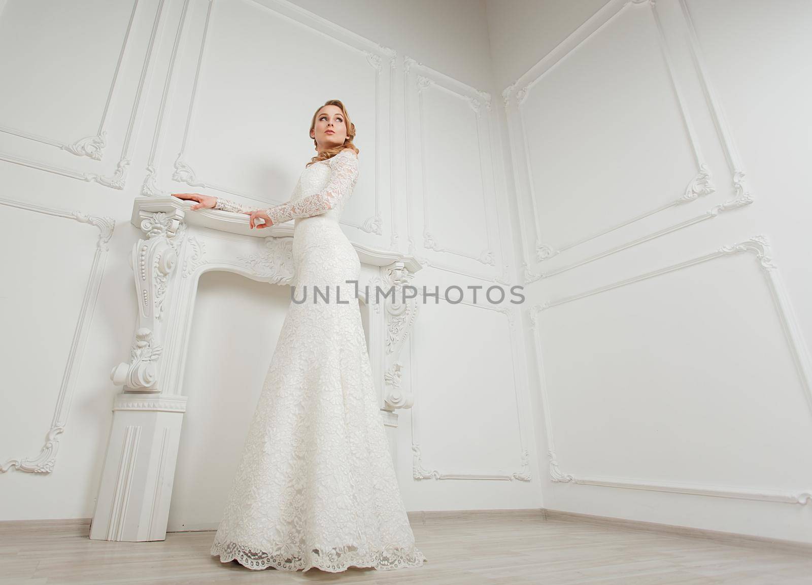 Full-length portrait of young gorgeous bride posing in antique interior.