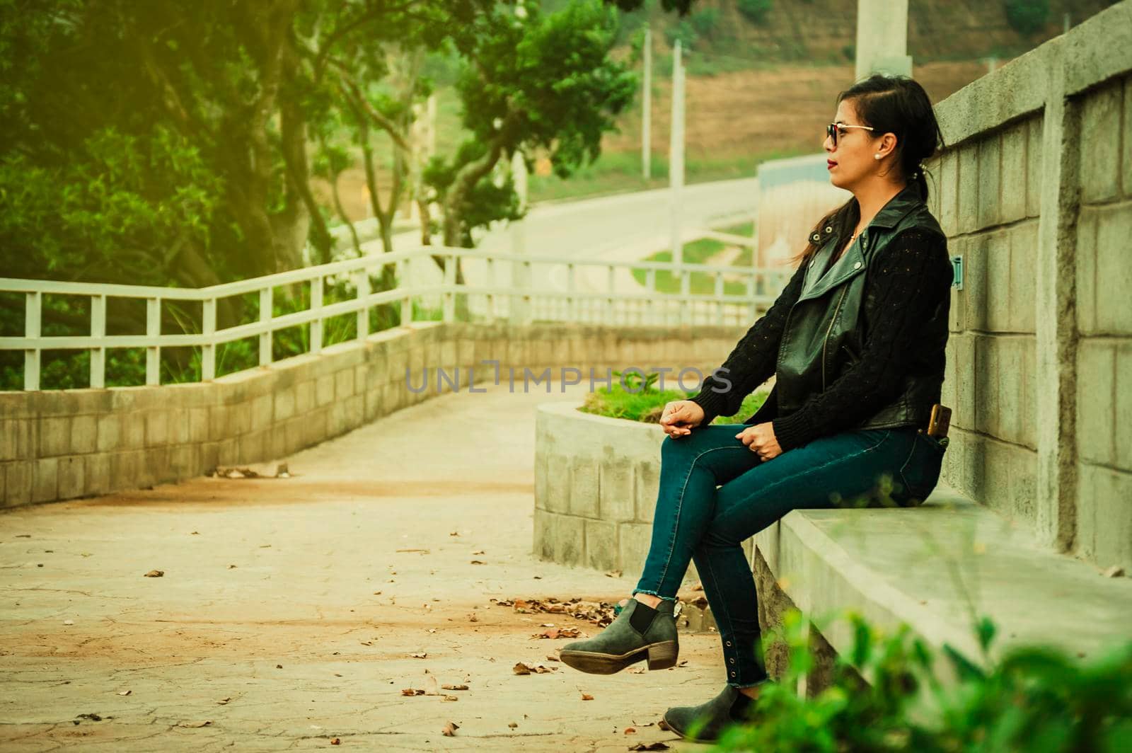 Latin girl with sitting on a bench, attractive girl with glasses sitting on a bench