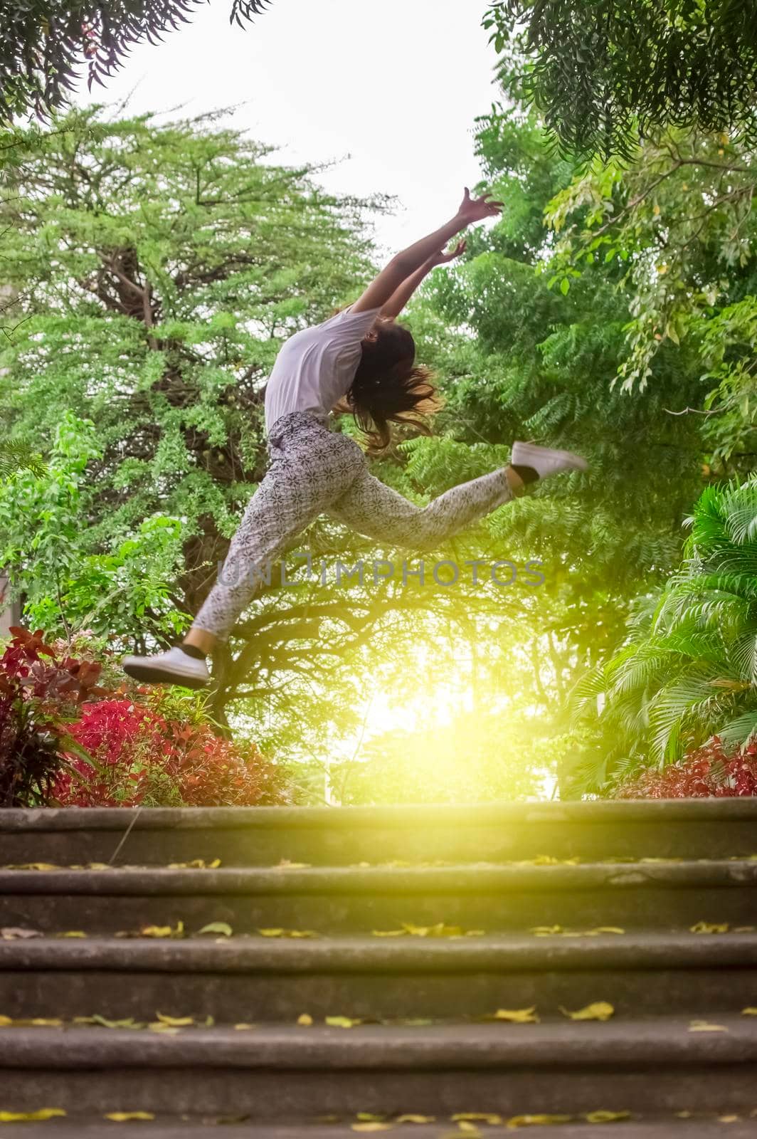 Girl jumping surrounded by trees, concept of happy girl jumping