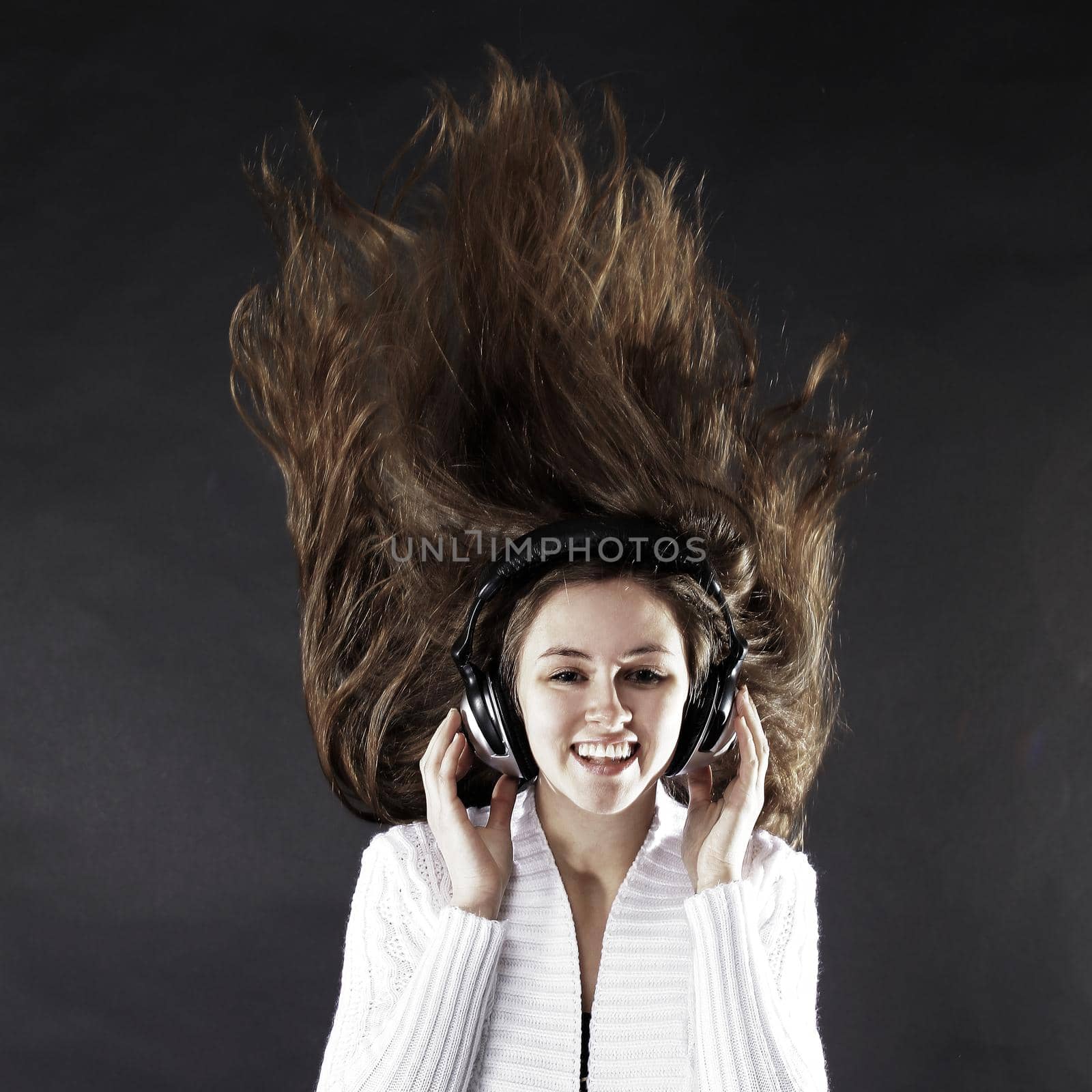 beautiful young woman listening to music with headphones .isolated on a black background. photo with copy space .